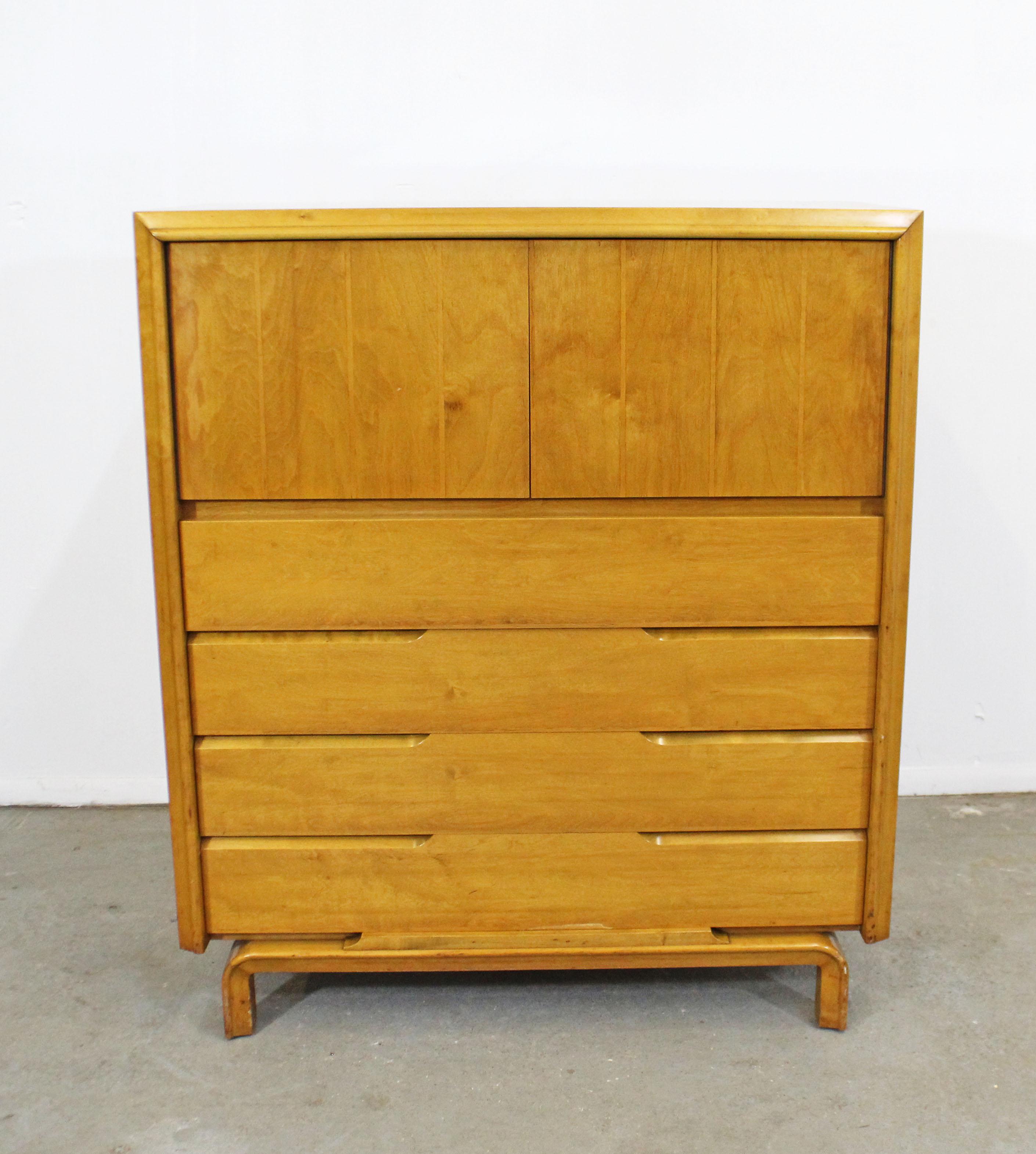 Offered is a beautiful Mid-Century Modern tall chest with ample storage space which was designed by American designer Edmond J. Spence. Features four bottom drawers and two doors with three inner storage compartments. Looks to be made of birch or
