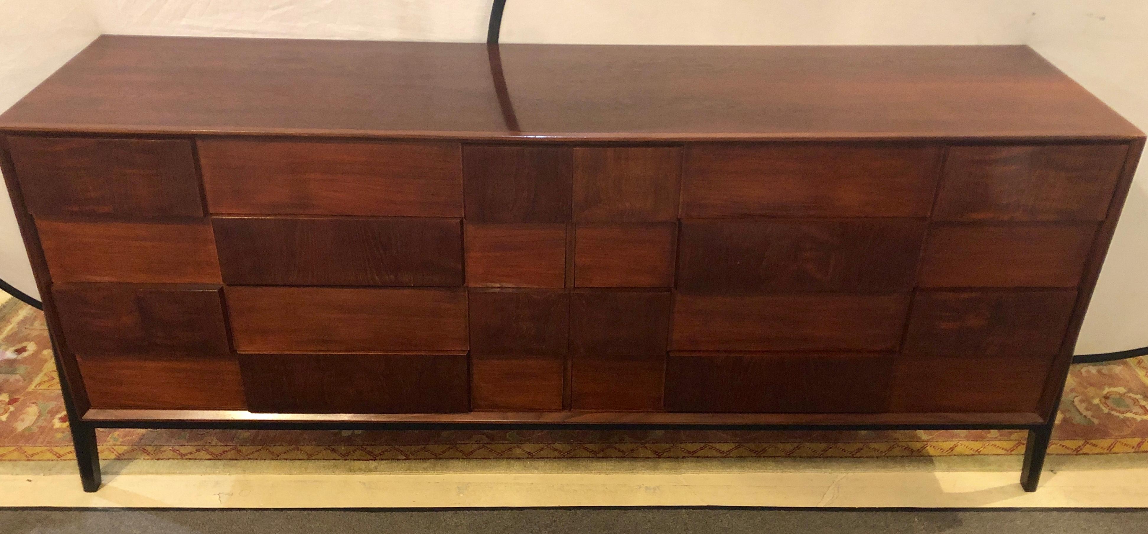 A Large and Impressive Mid-Century Modern Edmund Spence fashion double dresser in walnut and ebony. This recently refinished dresser has an ebony decorated undercarriage and four ebony legs supporting the four by four group of drawers made of check