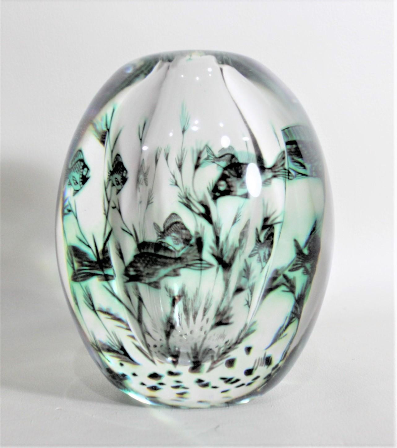 This Mid-Century Modern art glass vase was made by Edward Hald for Orrefors of Sweden in circa 1970 in the period Scandinavian Mid-Century style. The vase is done using the 'graal' or twice-blown technique and portrays a series of swimming green