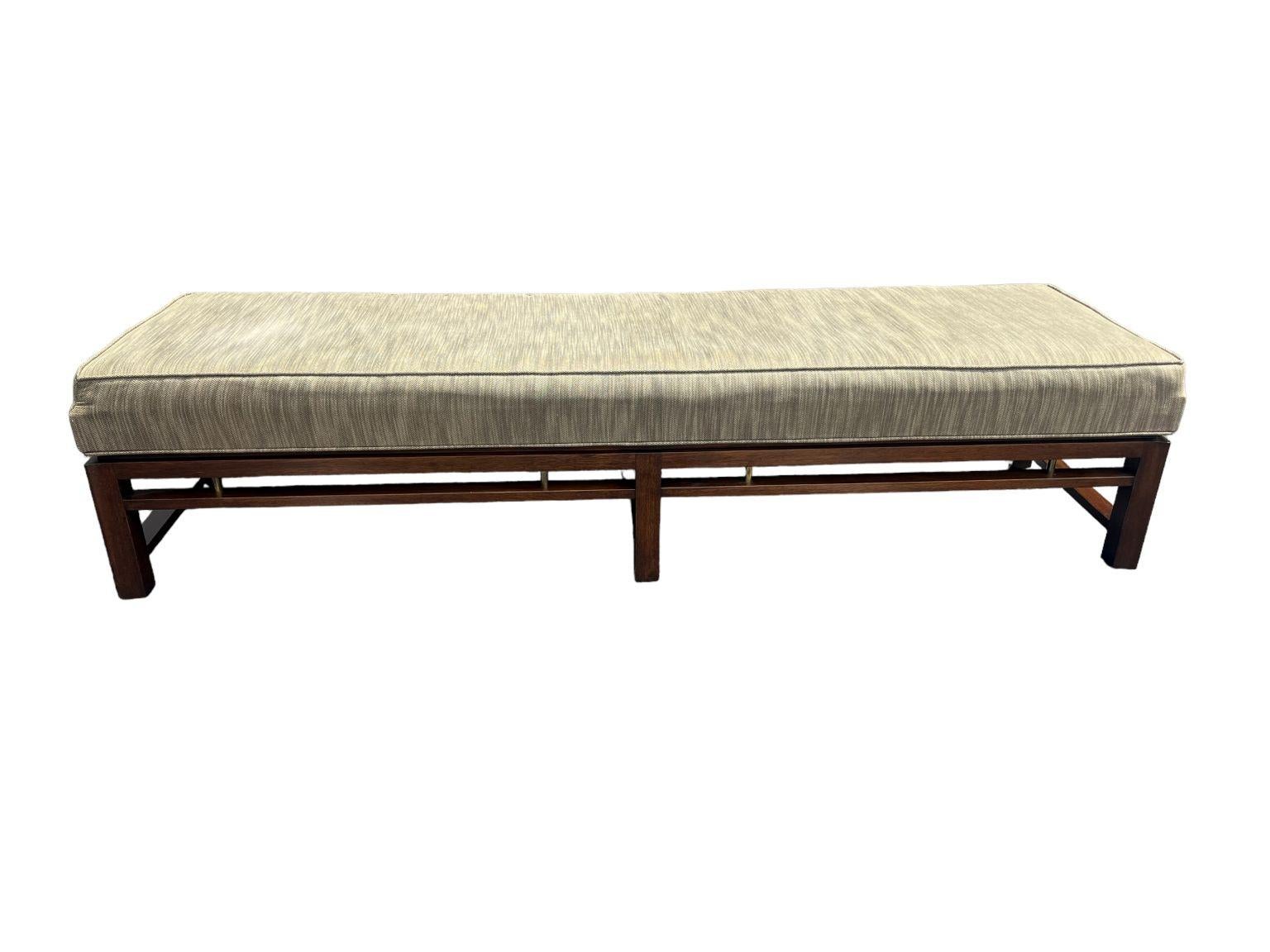       Original vintage Edward Wormley for Dunbar solid mahogany six-leg bench with brass accents. Newer cloth fabric and clean original finish. Reupholstering is recommended but not necessary. Finished on the reverse so it can float in a room or