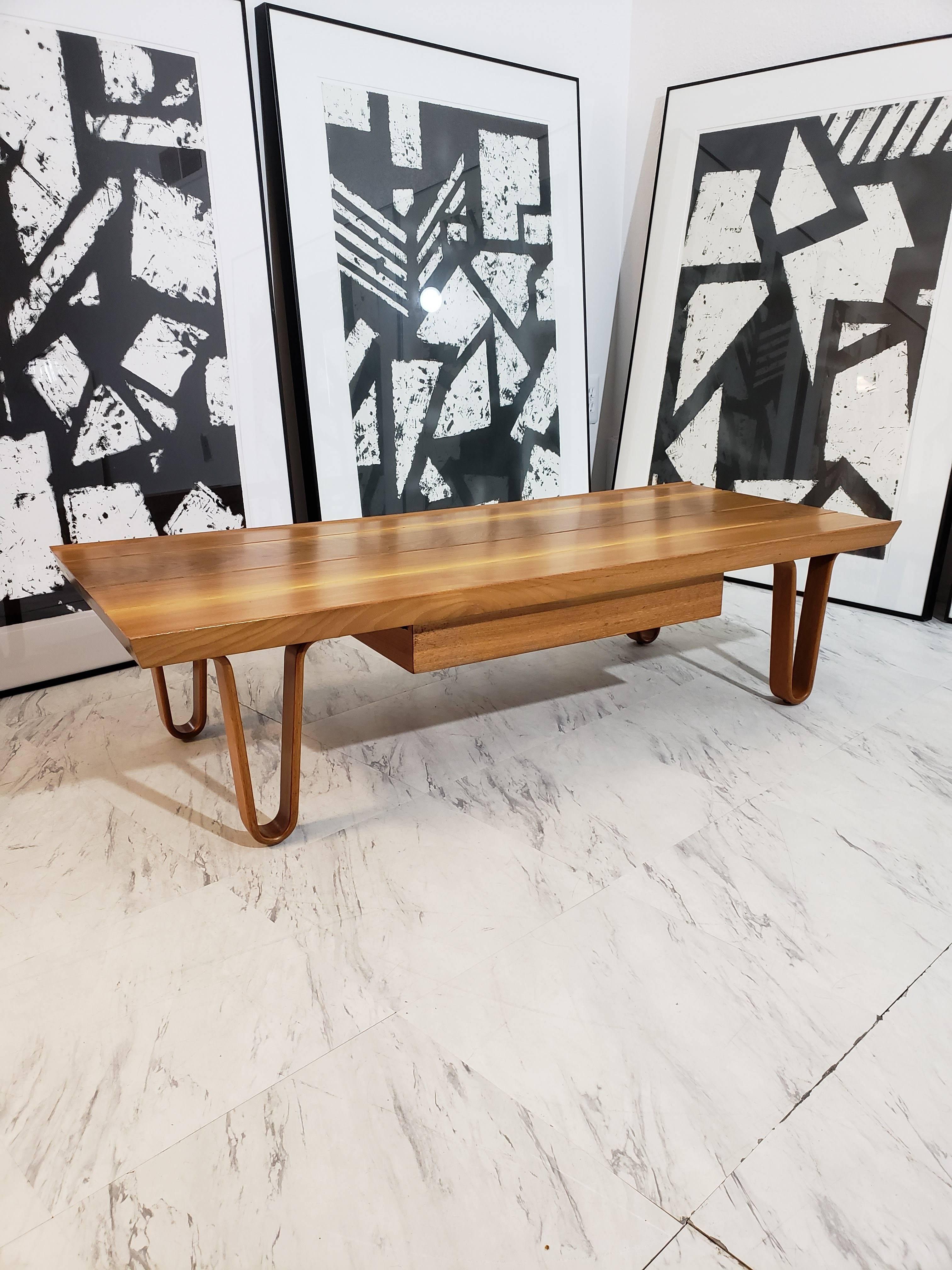 This coffee table/ bench is in excellent condition. Edward Wormley for Dunbar walnut low to the ground, sturdy, heavy with bentwood legs includes a drawer. Measure: width 46
