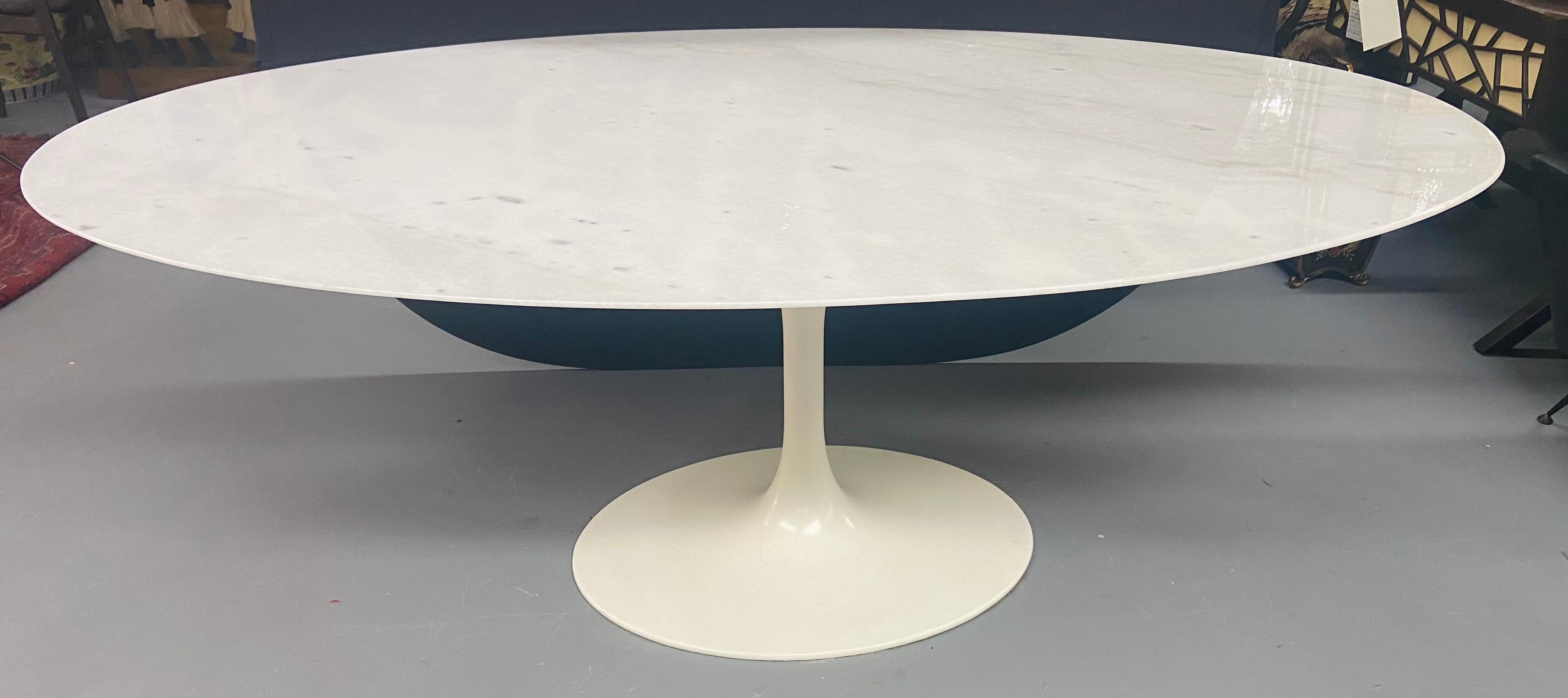 A Mid-Century Modern Eero Saarinen for Knoll oval marble-top dining table featuring a cast iron white lacquered base. This beautiful 78