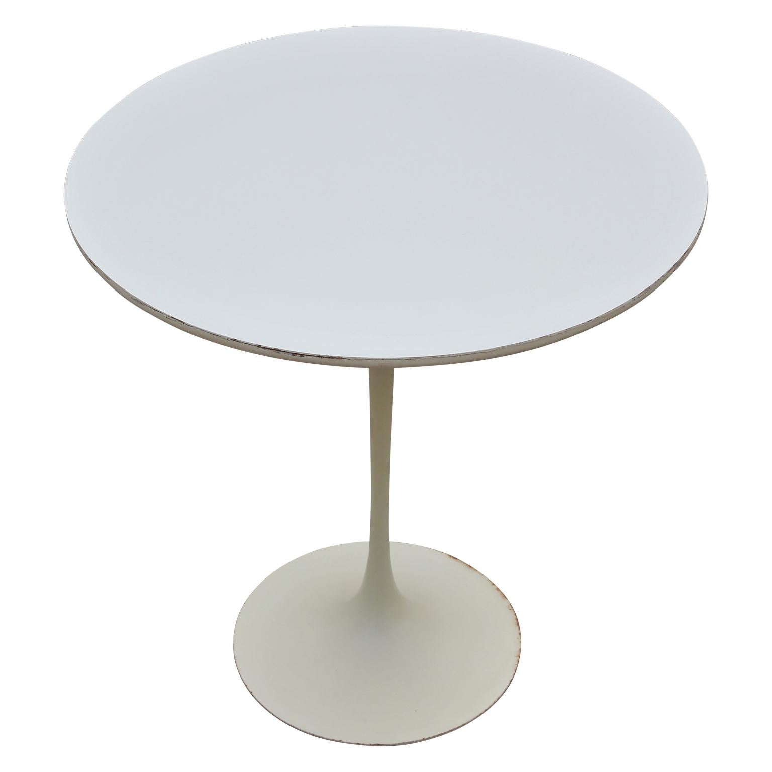 An excellent vintage E. Saarinen for Knoll side table. Early production with Knoll label present on the bottom of the table. 20 inch diameter round white laminate top with beveled underside edge. Cast iron base is powder coated in gloss white.