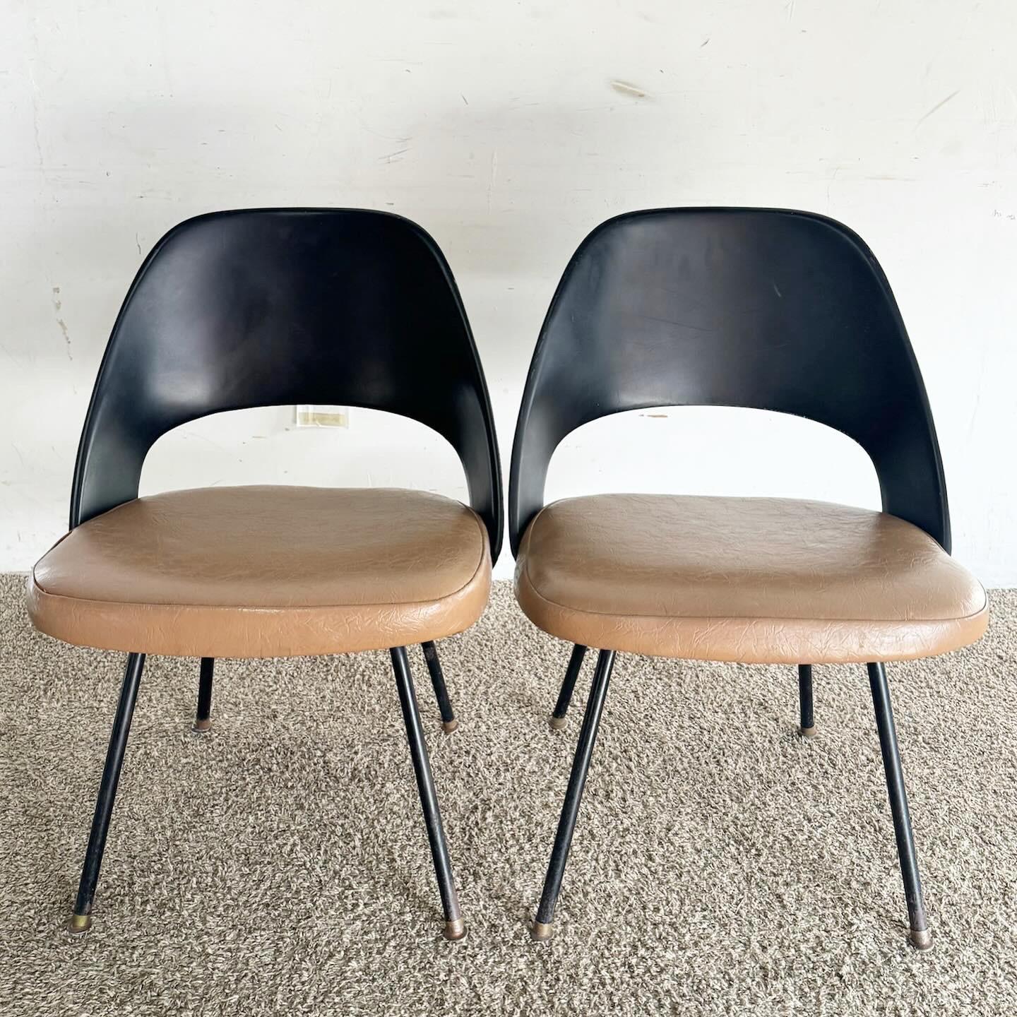 The Mid Century Modern Eero Saarinen Model 42 Style Dining Chairs, in a set of four, are a tribute to classic design. Featuring sleek black fiberglass backrests and elegant metal prong legs, these chairs capture Saarinen's timeless aesthetic. They