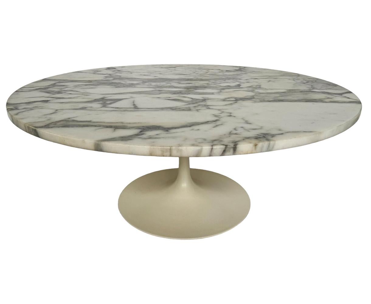 Authentic and signed 1960s coffee table designed by Eero Saarinen and produced by Knoll Associates. It features an off-white tulip base with a round slab of Arabescato marble. Top was replaced at some point and marked Italy. 