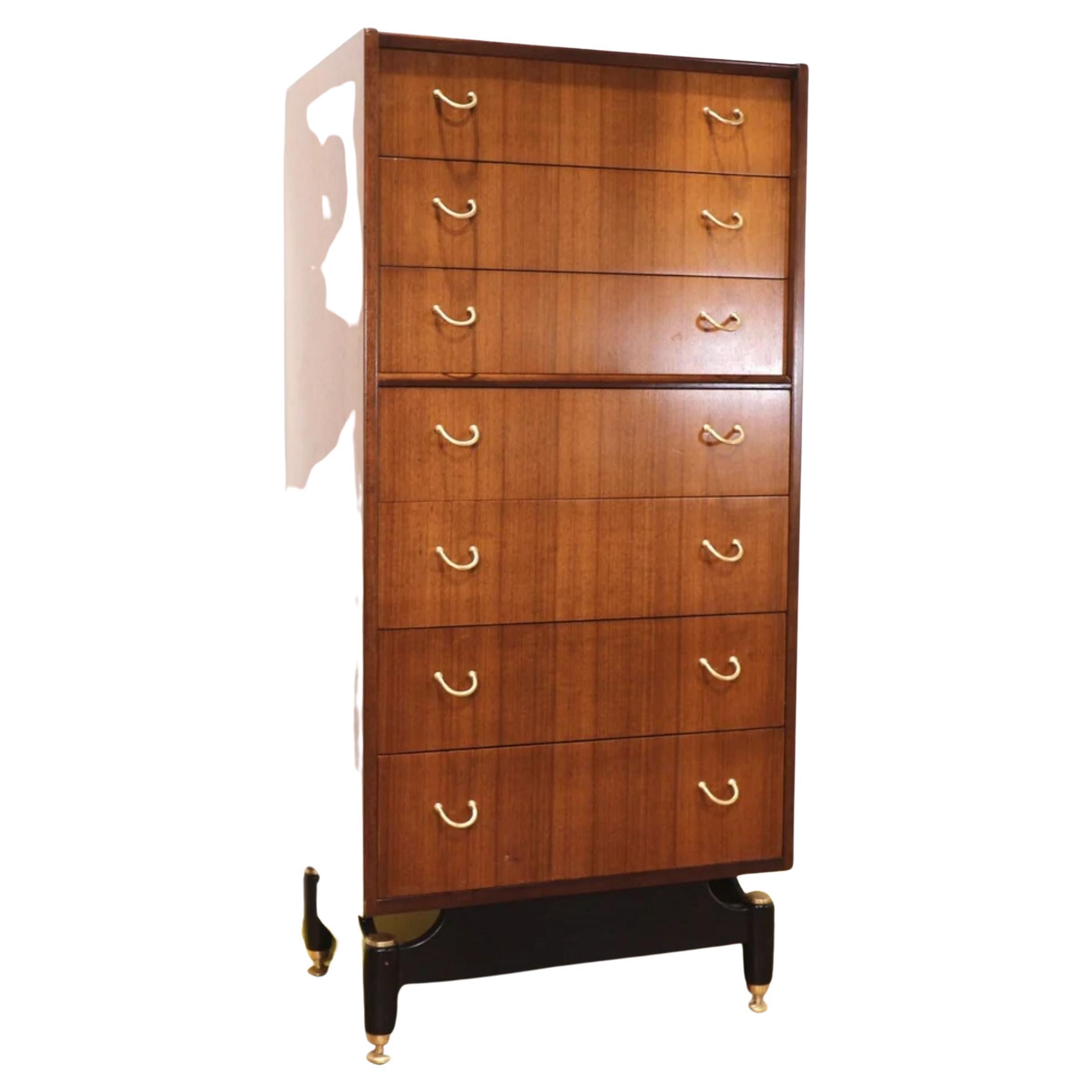 A stunning Mid-Century Italian style Tola Librenza tallboy dresser of 7 drawers by E Gomme (G Plan) on black plinth/legs with polished brass caps, adjustable brass riser feet & ergonomic curved brass handles

Dimensions

Width 24 depth 16 height
