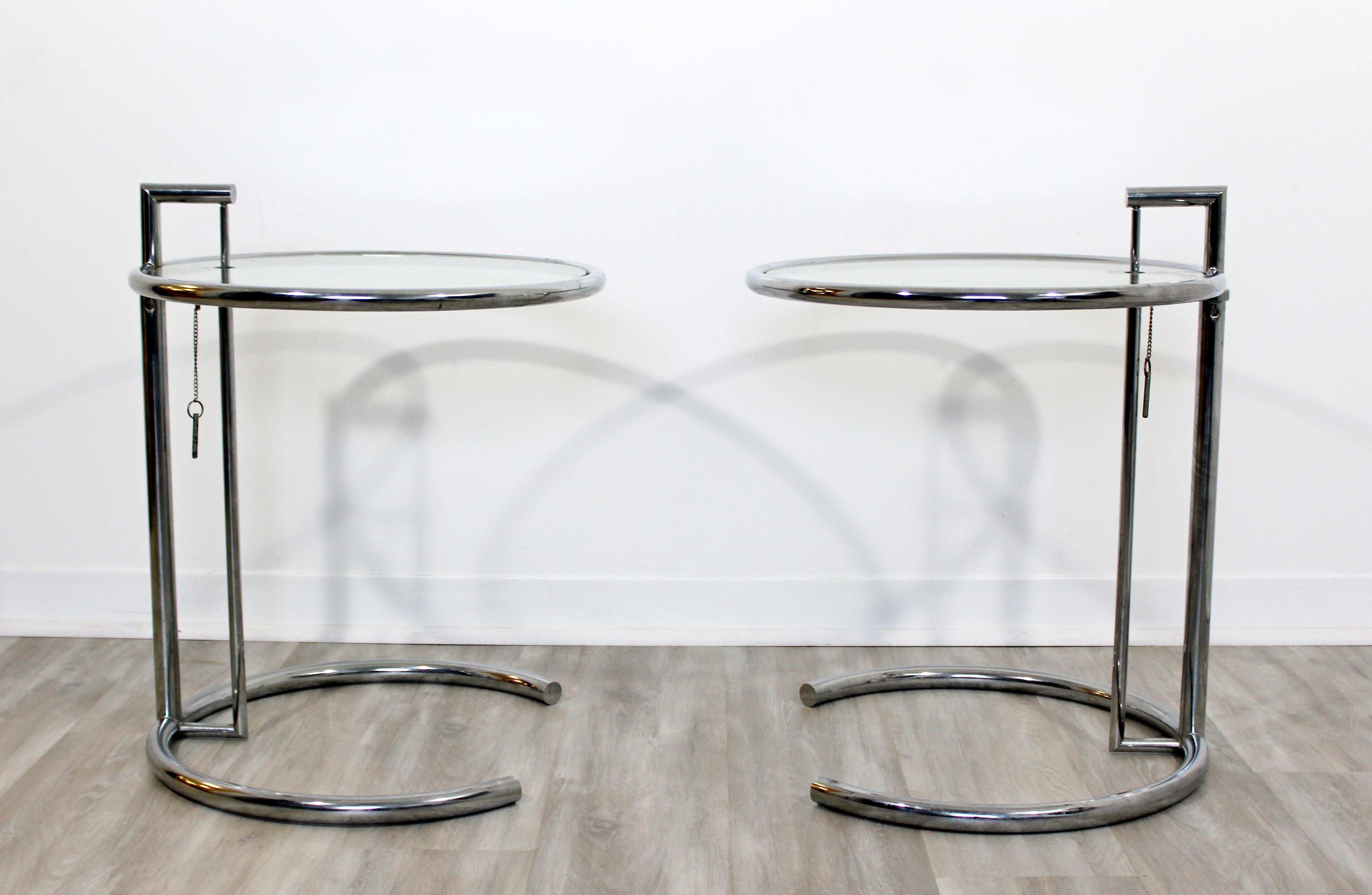 For your consideration is a gorgeous pair of adjustable, round, side or end tables, made of chrome and with glass tops, by Eileen Gray, circa 1960s. In good vintage condition, with a chip in one of the glass tops. The dimensions of each are 20