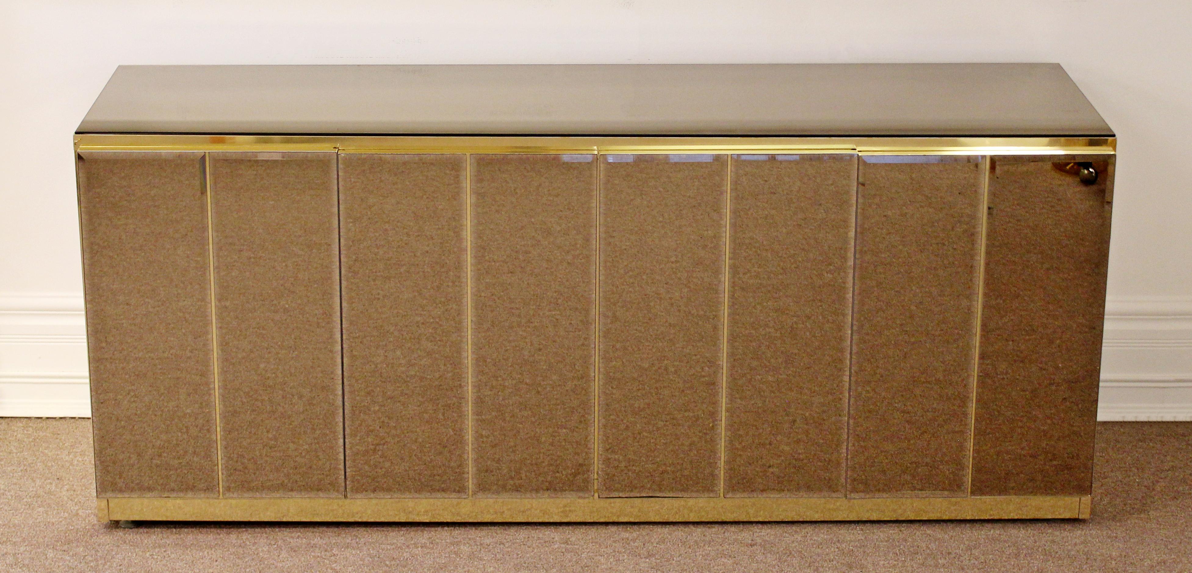 For your consideration is a fabulous credenza, made of brass and smoked mirror by Ello, circa 1970s. In very good vintage condition. The dimensions are 72