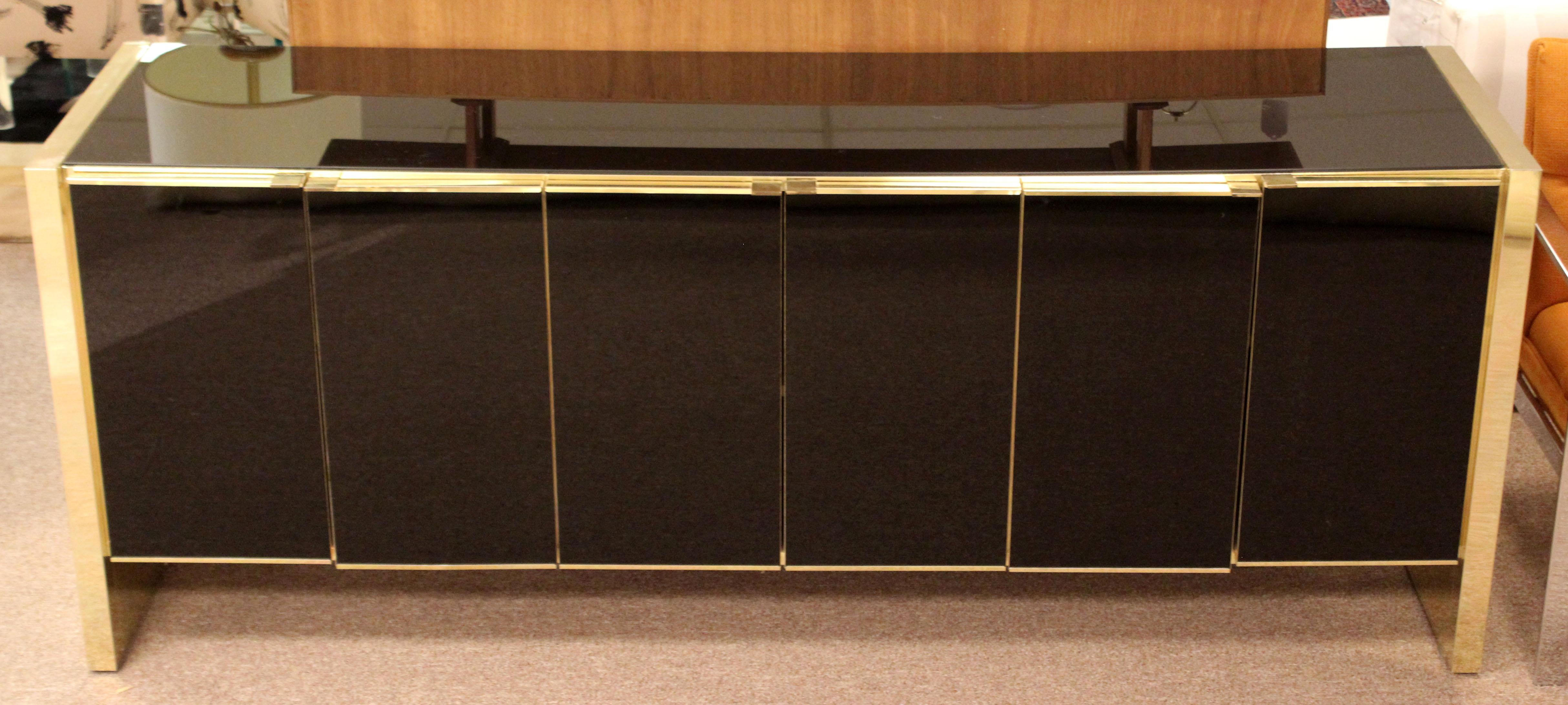 For your consideration is a fabulously chic credenza sideboard, with smoked mirrored top and doors and brass trim, by Ello Furniture, circa 1970s. In very good condition. The dimensions are 75.5
