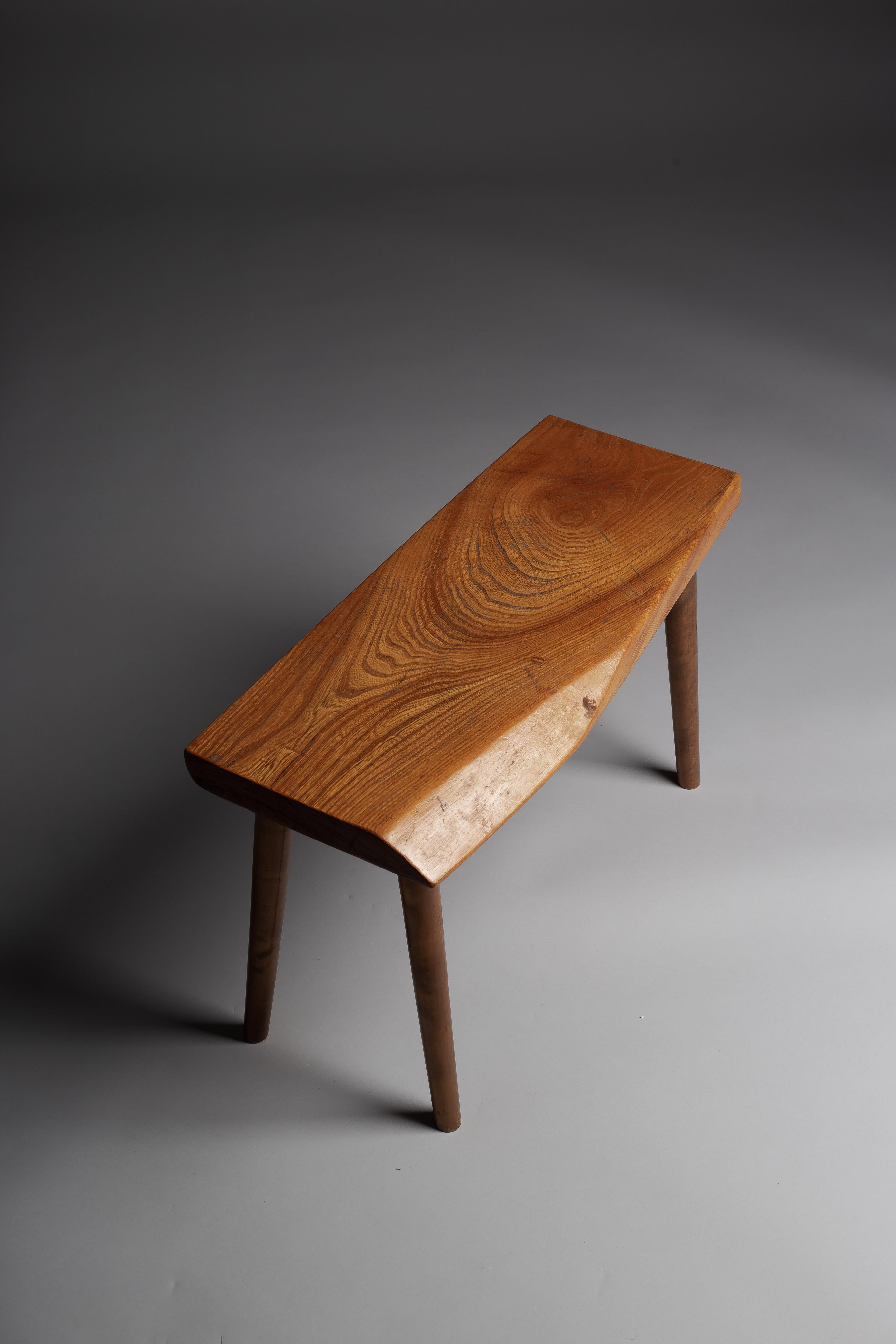 Découvrez l'essence de l'élégance moderne du milieu du siècle avec notre impeccable tabouret en orme dans le style Georg Nakashima. Ce tabouret présente un grain magnifique et époustouflant qui ajoute une touche de sophistication naturelle à