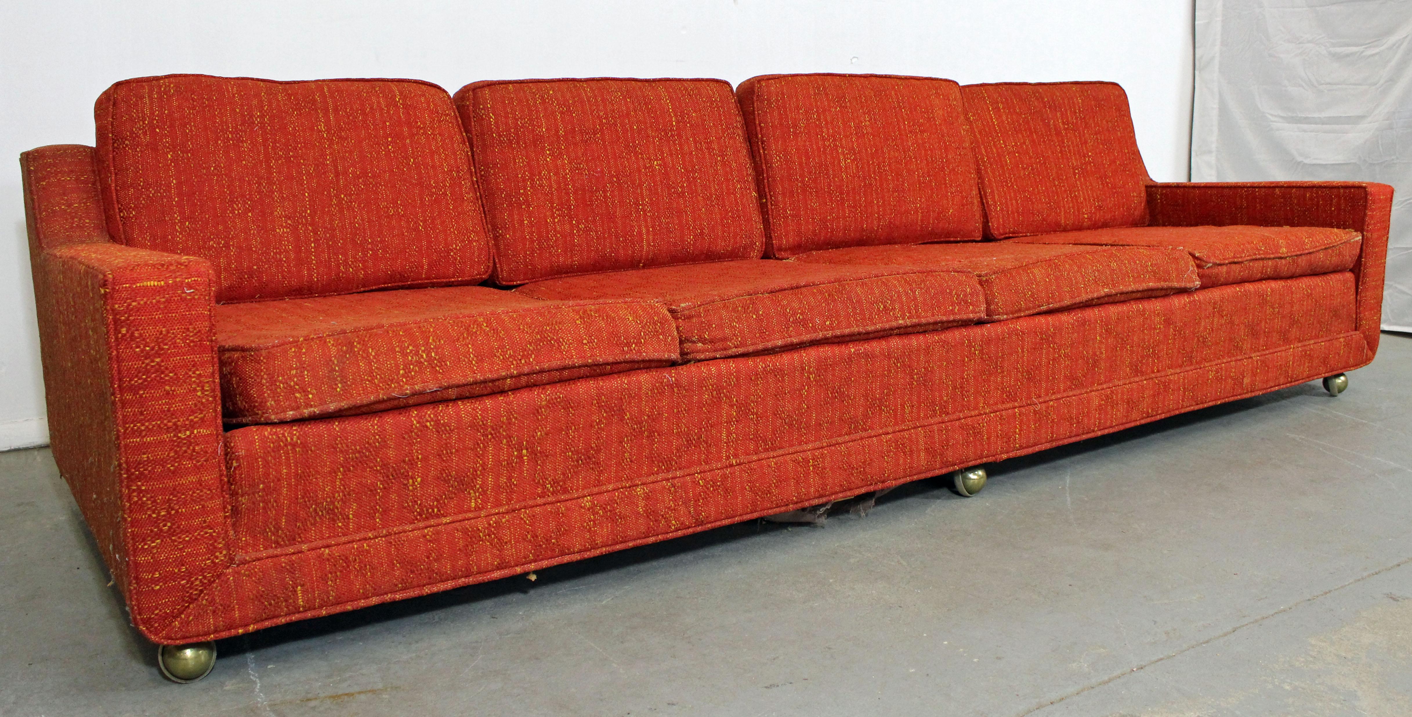What a find. Offered is an elongated midcentury sofa with four seats by Kroehler. Features three castor wheels in front and wood legs in back, which makes for easy moving. Perfect for entertaining! It is structurally sound showing age wear. Will