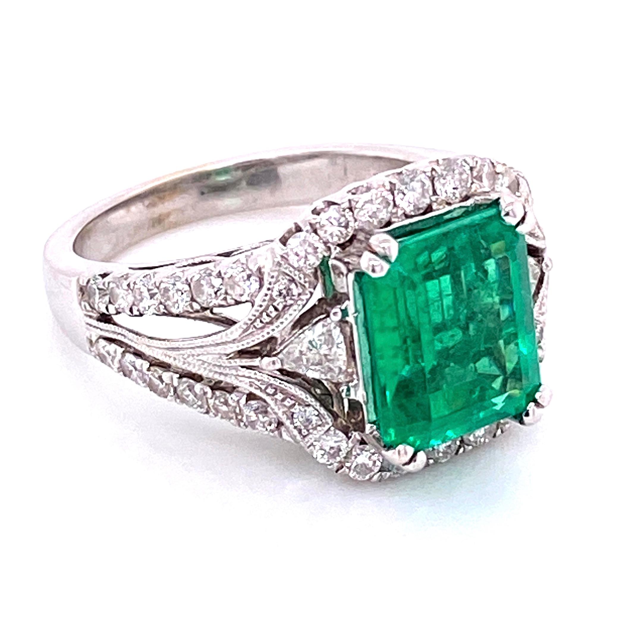Simply Beautiful and finely detailed White Gold Cocktail Ring, center Hand set with a securely nestled 2.75 Carat Emerald-cut Emerald, Amazing color! Surrounded by round Diamonds, weighing approx. 1.20tcw, including side Diamonds enhancing the