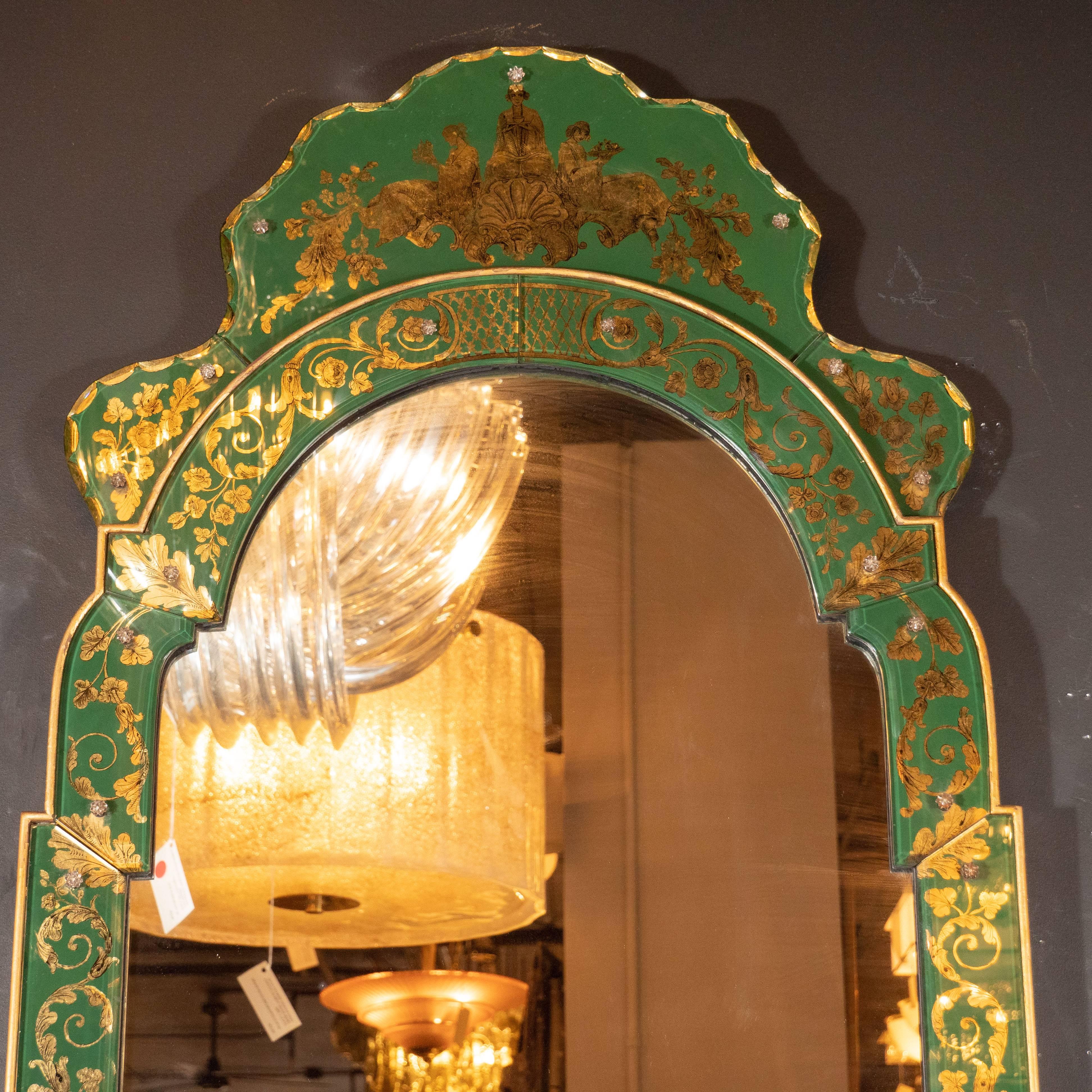 This elegant mirror was realized in the United States, circa 1950. It features an arch form body of giltwood with curvilinear and architectonic detailing; beveled gilded edges; and neoclassical motifs in reverse églomisé. Three female figures