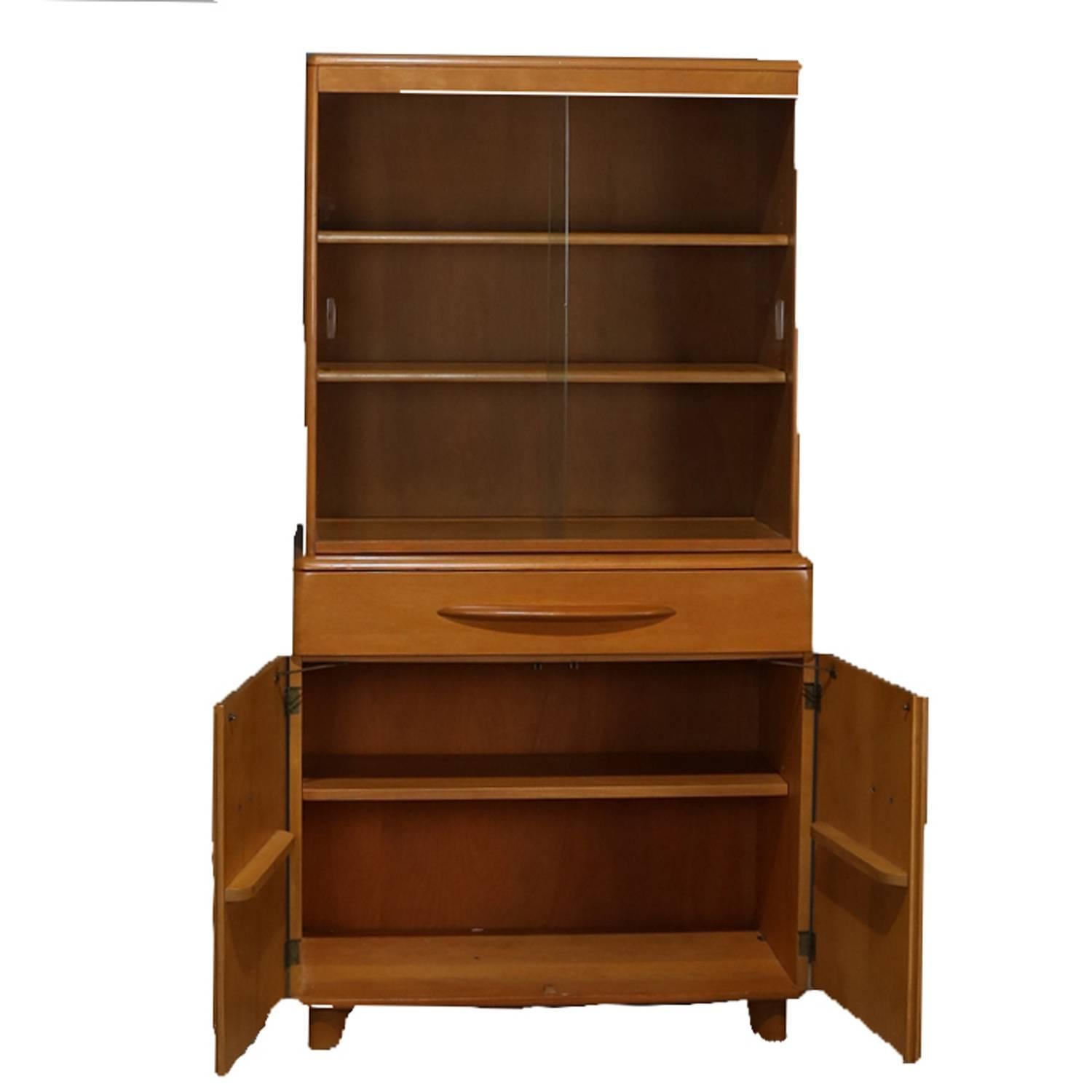 Mid-Century Modern, China cabinet or step back cupboard by Heywood Wakefield in Encore features wheat finish, upper with sliding glass doors opening to adjustable shelved interior, lower with long drawer above double door cabinet opening to shelved