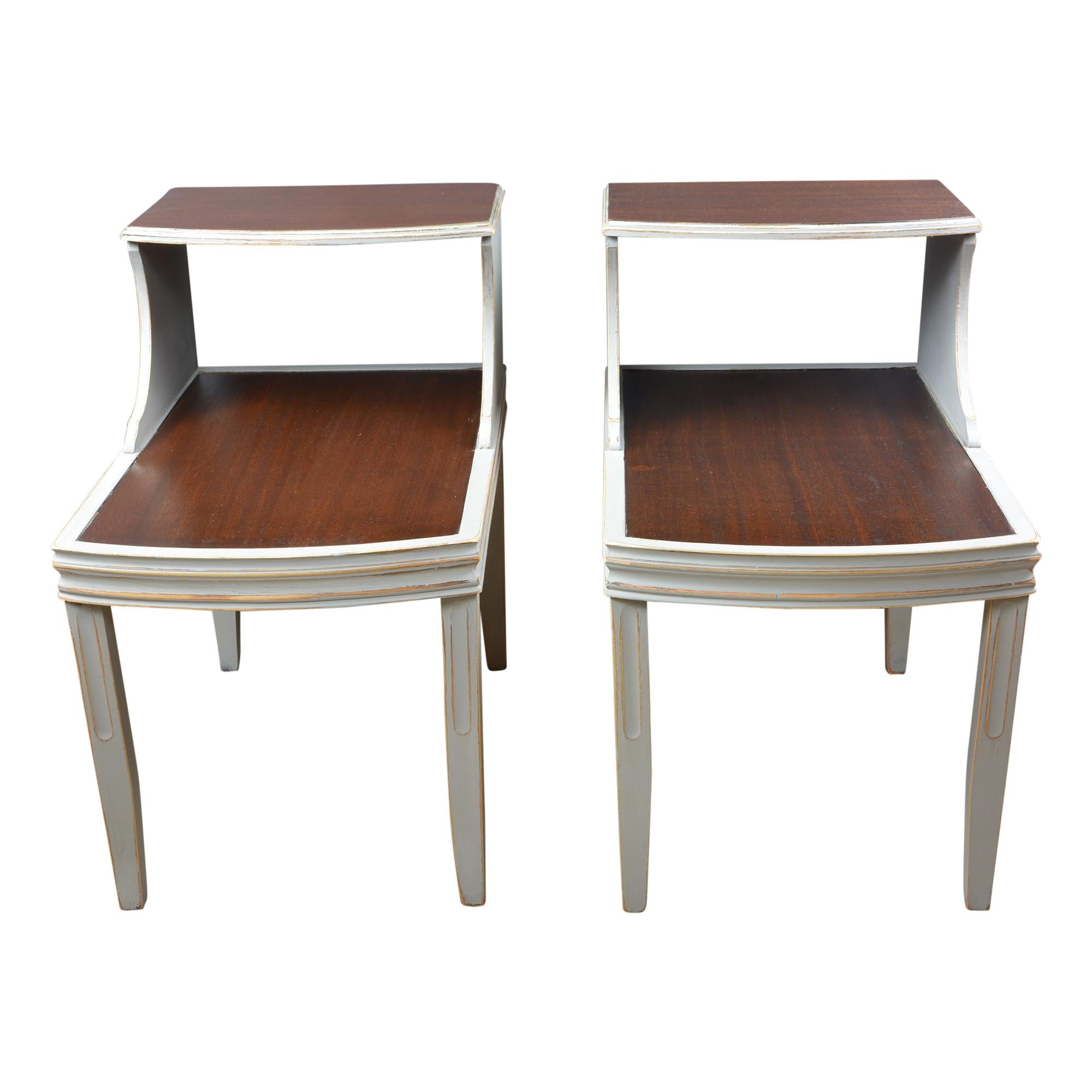 The clean lines of these MCM end tables are such a classic look of the time. They feature the two levels of table tops which was so popular at the time. The pair are recently hand painted gray and multi-layered browns. The sleeker design and slender