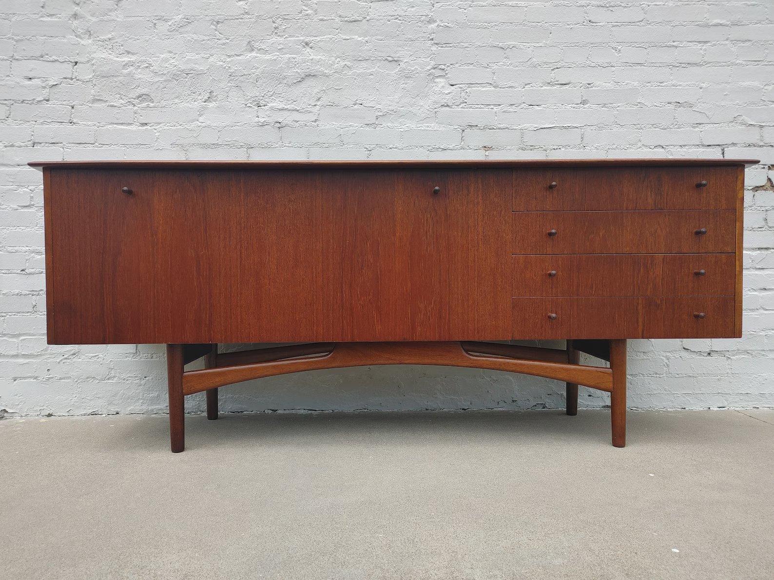 Mid Century Modern English Teak Sideboard

Most likely by Younger from England.  Above average vintage condition and structurally sound. Has some expected slight finish wear and scratching. Top has been refinished and does not have original factory