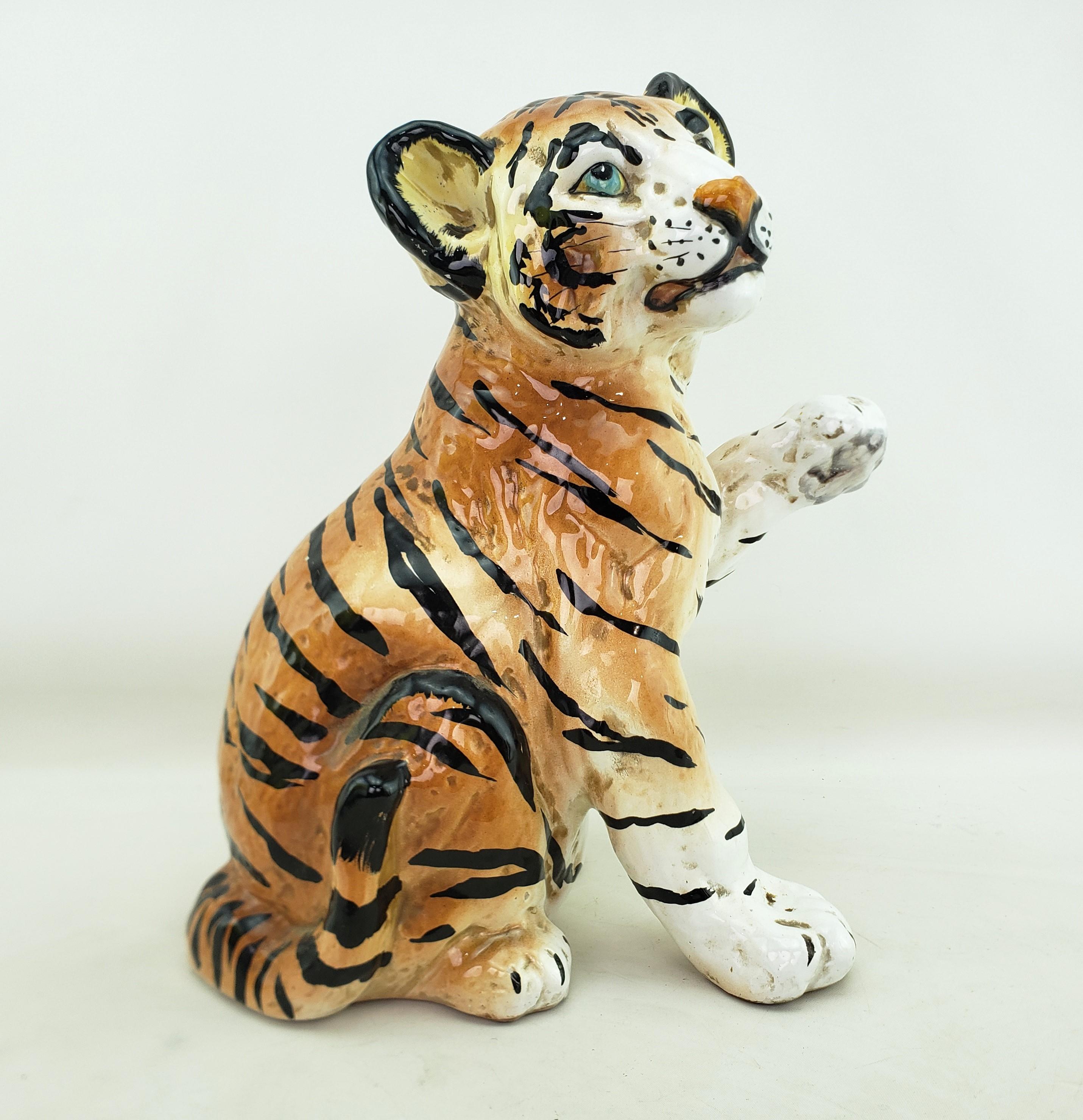This sculpture shows no artist's signature, but originated from Italy and dates to approximately 1965 and done in the Mid-Century Modern Ronzan style. The sculpture is composed of thick ceramics depicting a seated tiger cub which has been