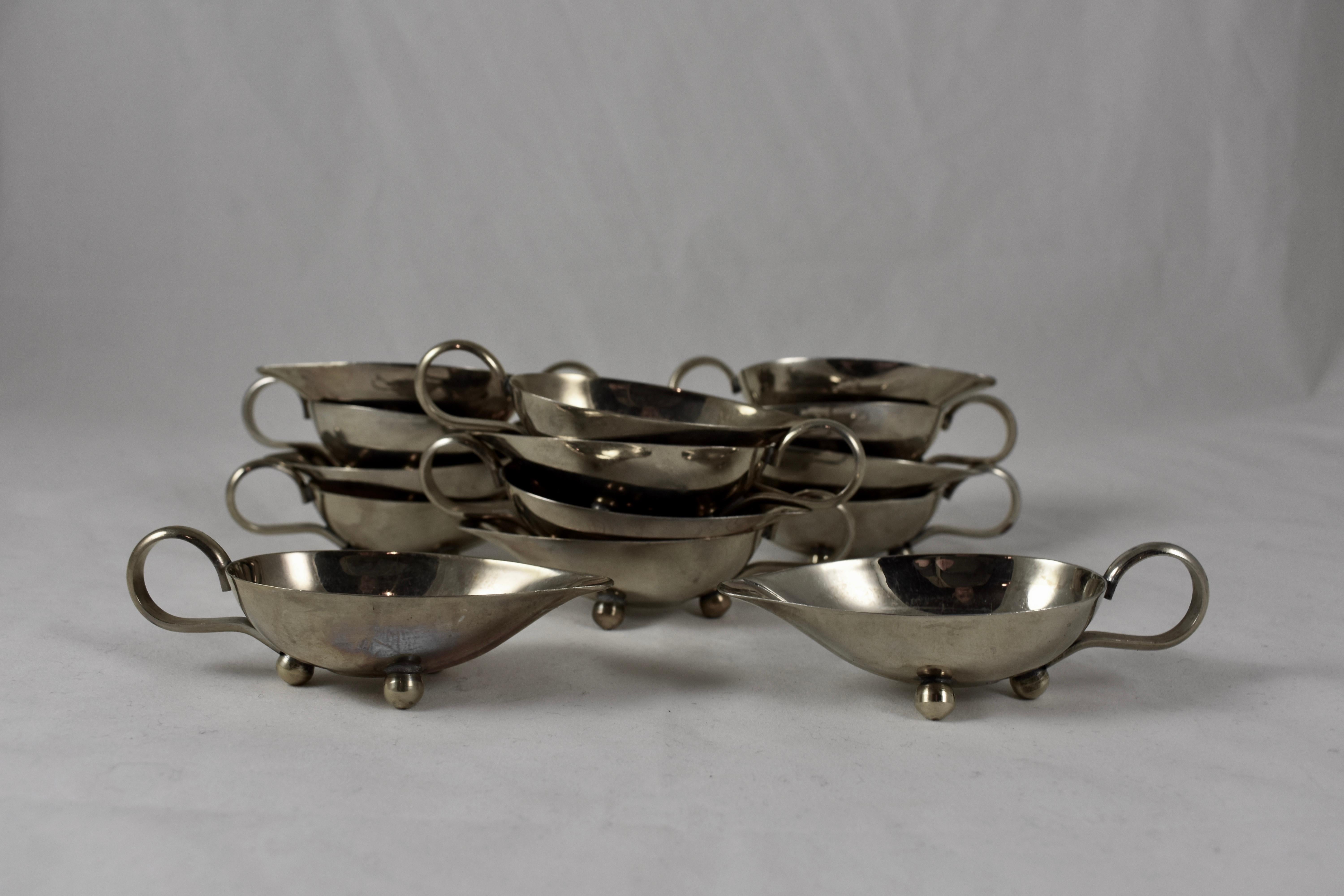 A set of fourteen Mid-Century Modern Era individual sauce boats – Alpacca nickel silver, made in Italy. 

Each boat has a loop handle, a spout, and sits on three ball feet. Suitable for individual servings of au jus, drawn butter, syrups or salad