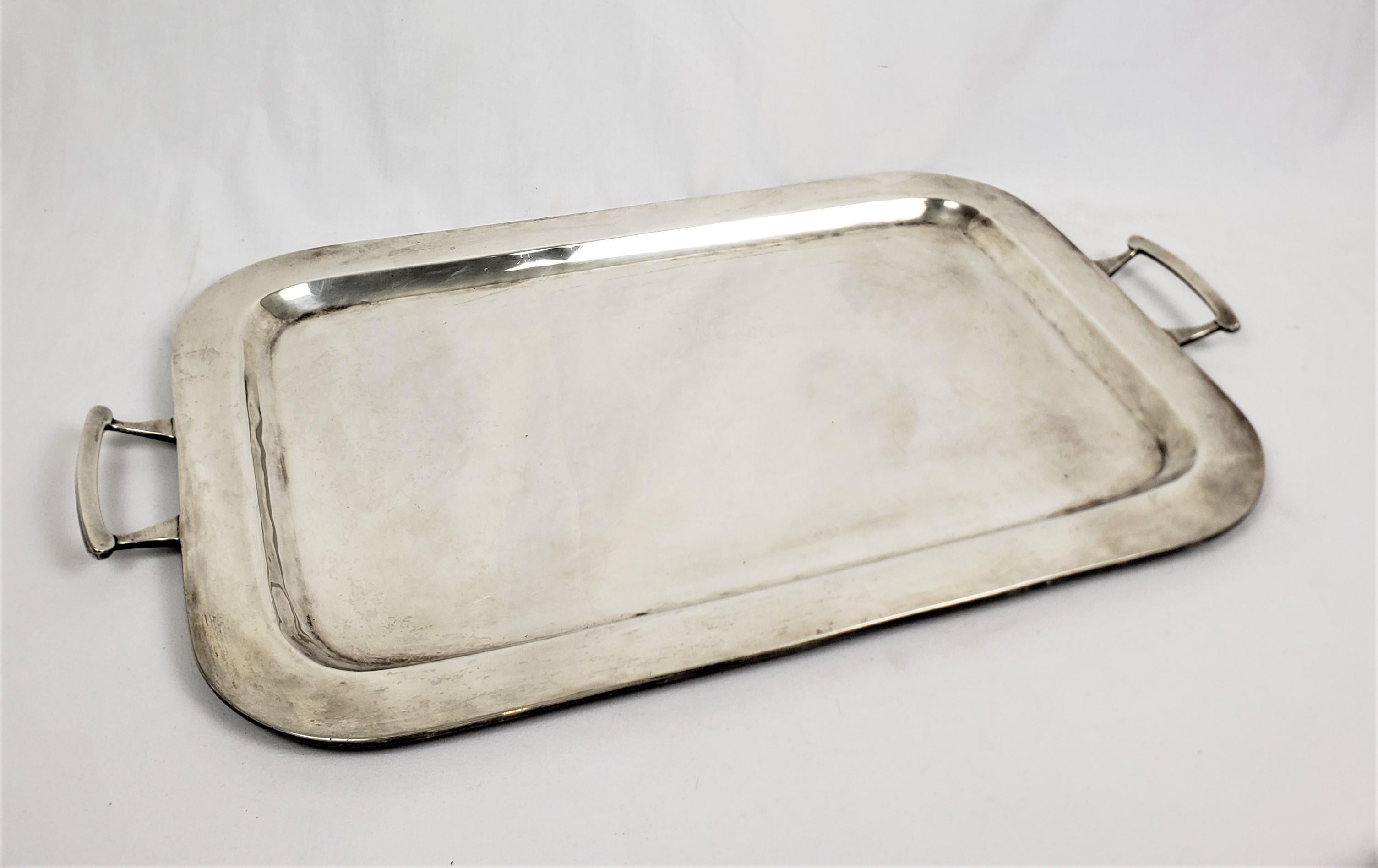 This sizable and substantial serving tray originated from Mexico and dates to approximately 1960 and done in the period Mid-Century Modern style. The tray is composed of sterling silver with a rectangular shape and applied post handles. The tray is