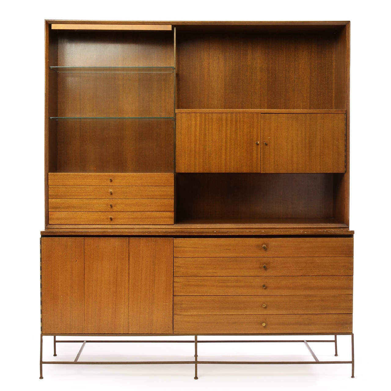 A well scaled Mid-Century Modern étagère in bleached walnut designed by Paul McCobb. The cabinet or shelf set is constructed in solid walnut wood and brass and features two separate lower or upper cabinet units. The lower cabinet with drawers and a