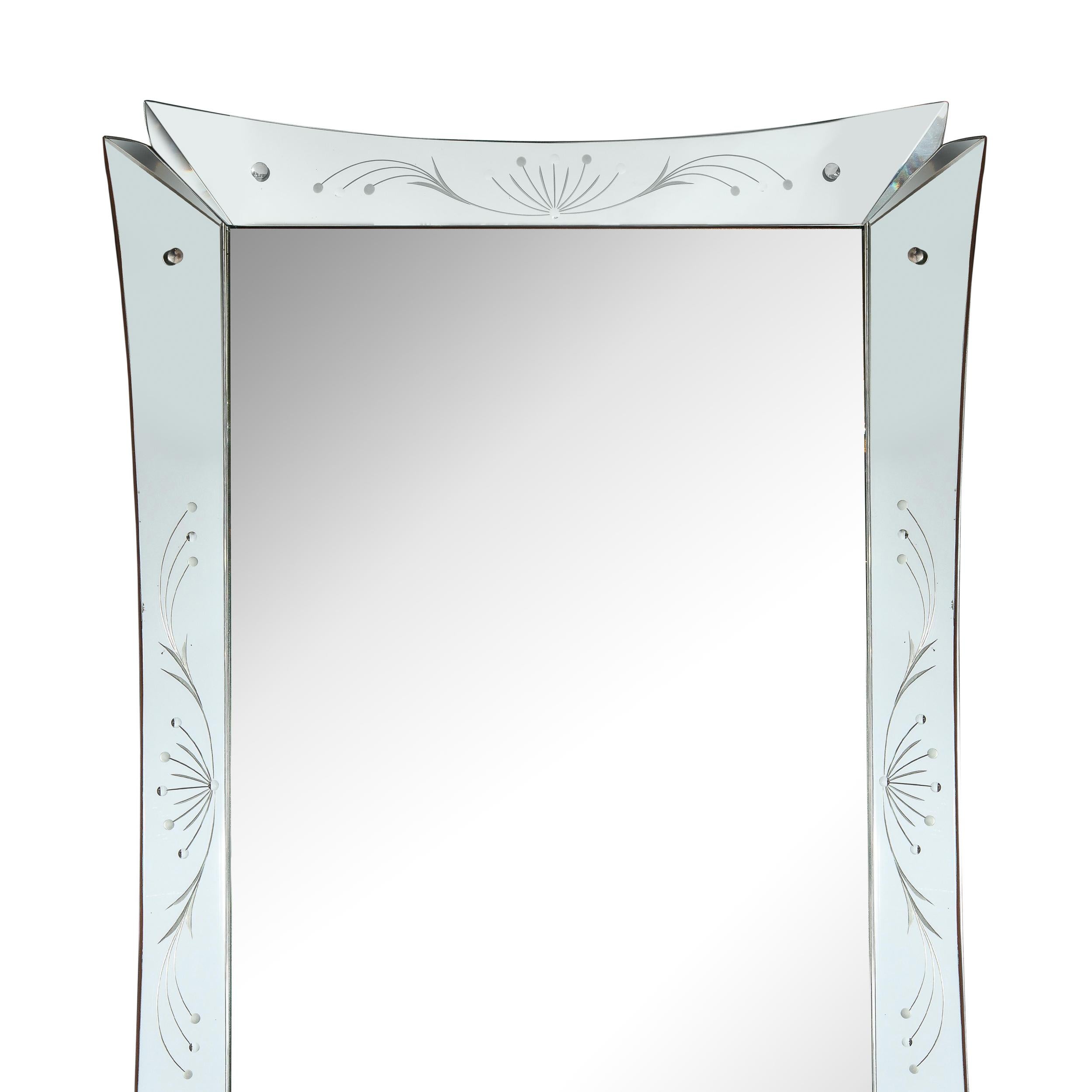 This stunning Mid-Century Modern mirror was realized in the United States circa 1950. It features etched stylized foliate patterns- offering flowing curvilinear lines capped with circular forms- on each of the four panels, along with circular nickel