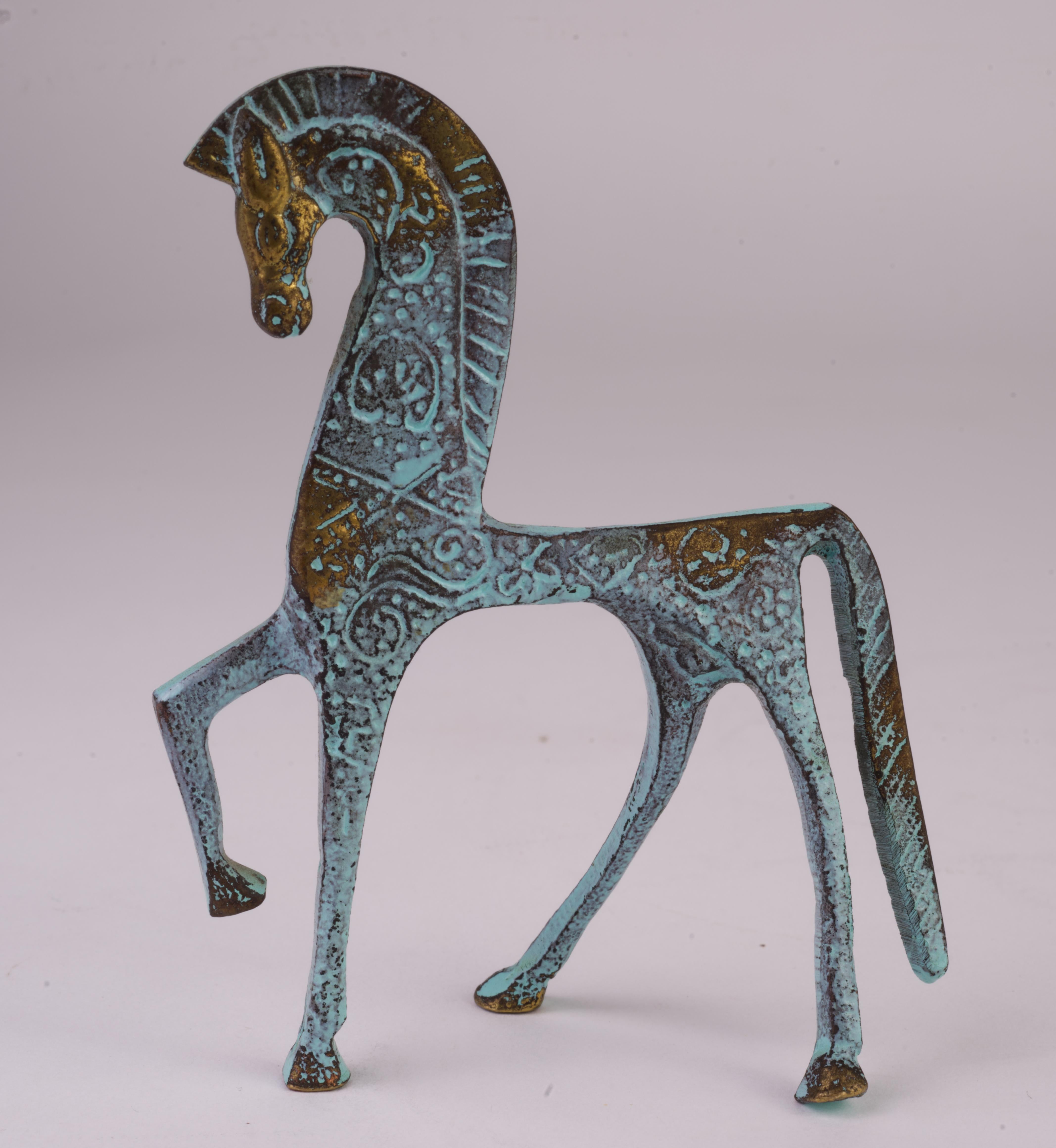 Vintage small Etruscan horse cast bronze figurine in the style of Frederick Weinberg is decorated with complex detailed etchings along the horse's body that are emphasized by strategic use of enamel, creating an antiquated impression. The etchings