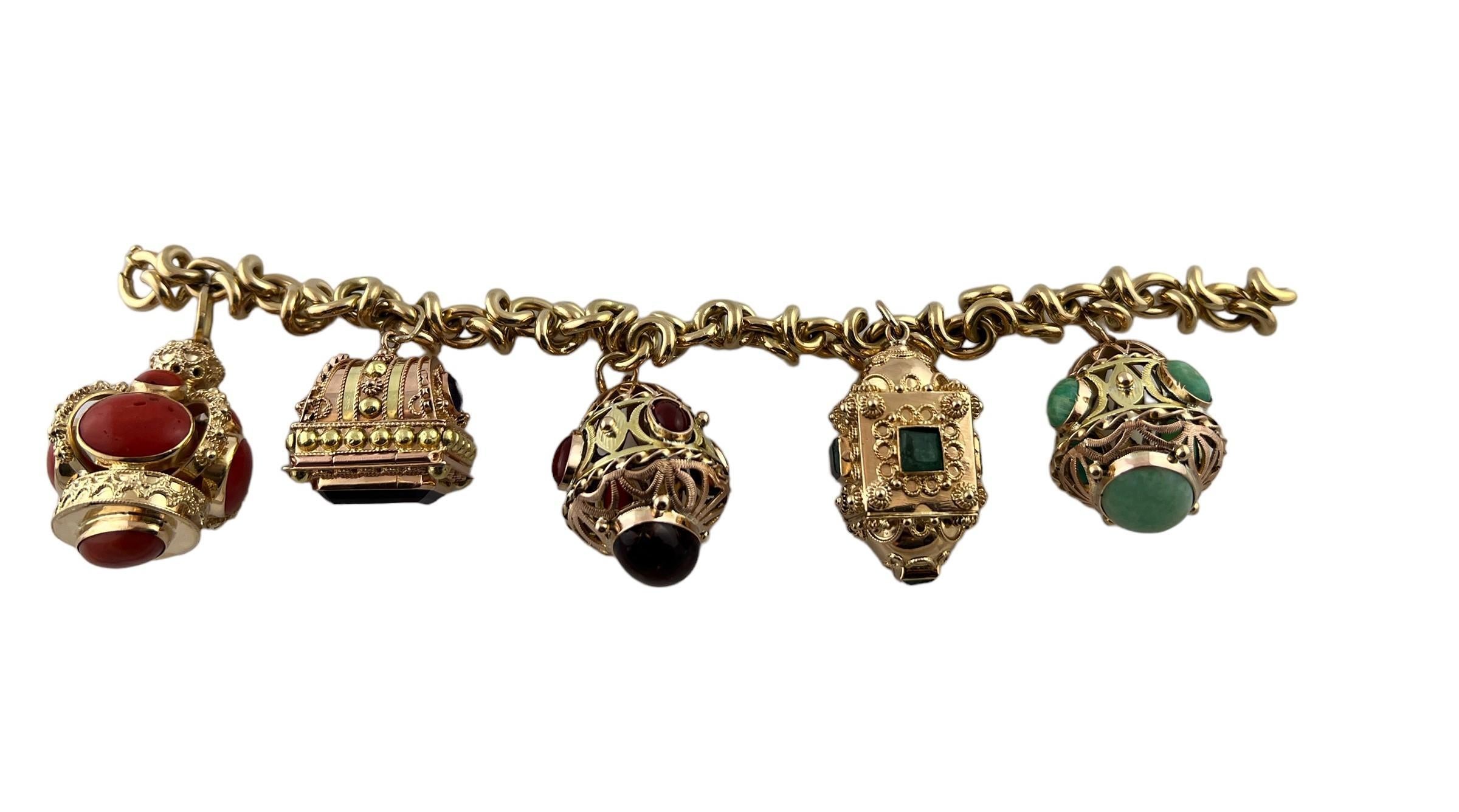 This beautiful mid century modern Etruscan revival bracelet is set in 18K yellow gold. 

This heavy bracelet is set with assorted semi precious stones. - light scratching, chips to some stones as shown

2 of the charms open as shown. 

8