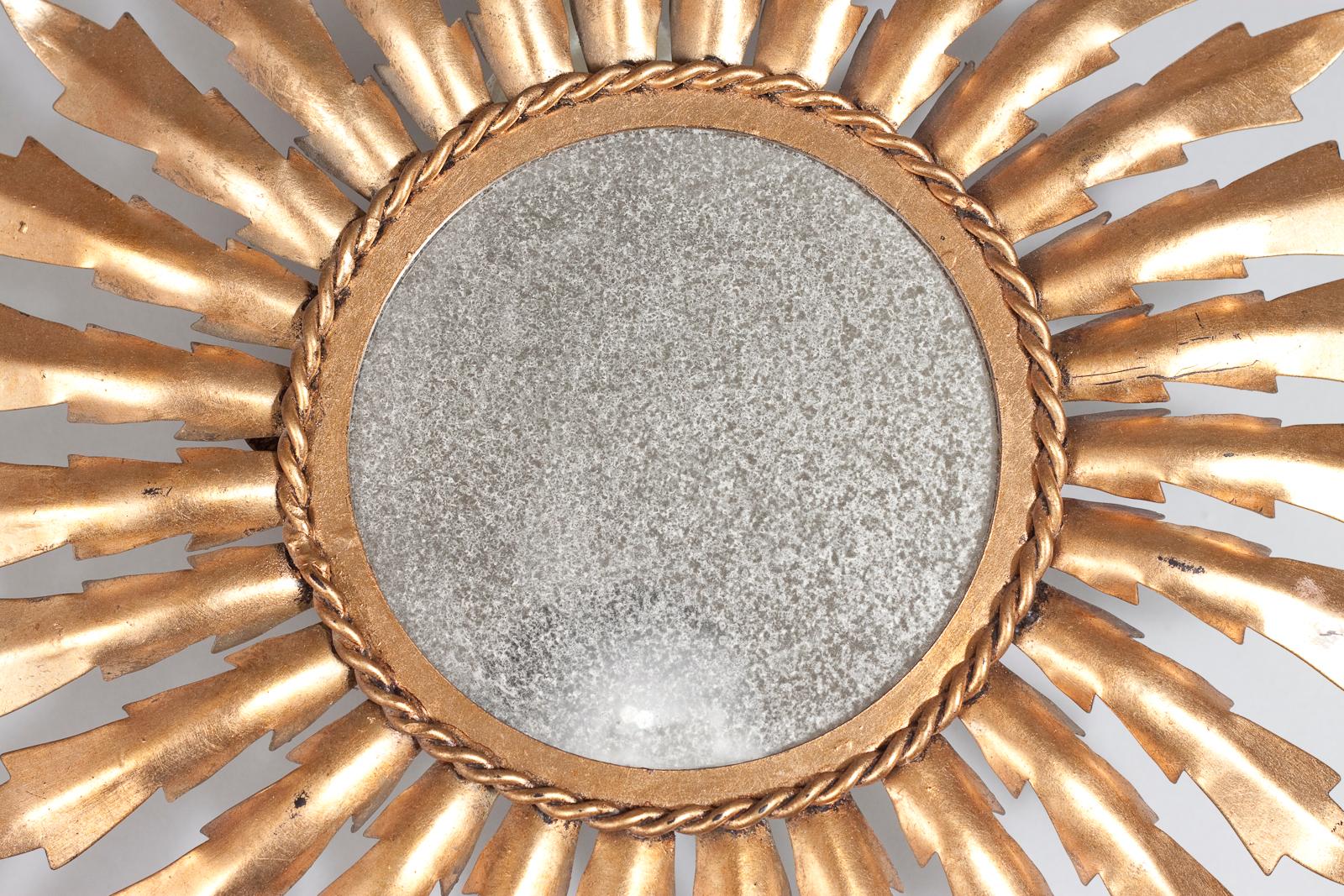 Popular sunburst European wall mirror in gilt metal.