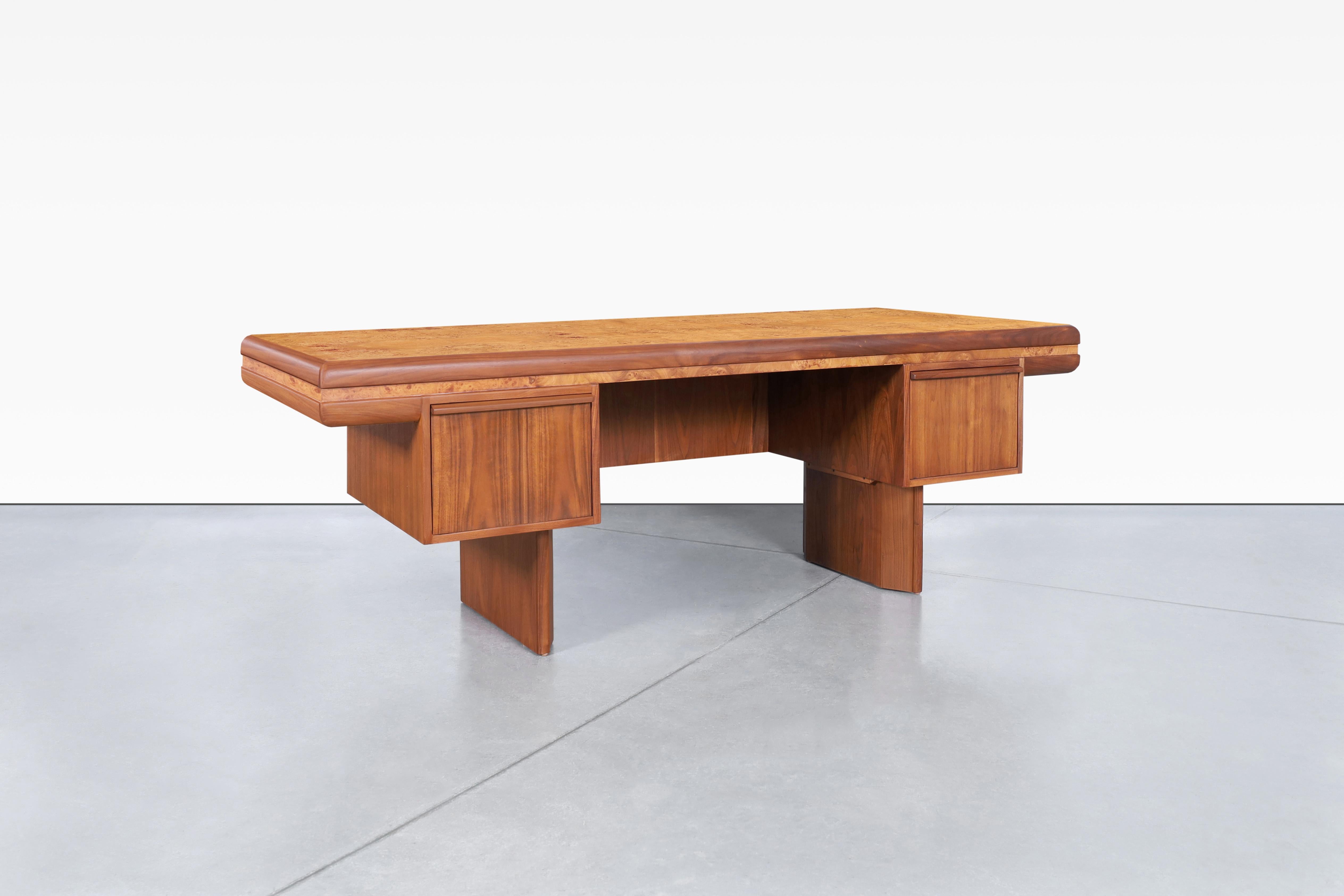 This stunning mid-century executive desk was designed in the United States and dates back to the 1960s, embodying an exceptional design that truly stands out. Its spacious working surface offers ample room for productivity, while the two large file