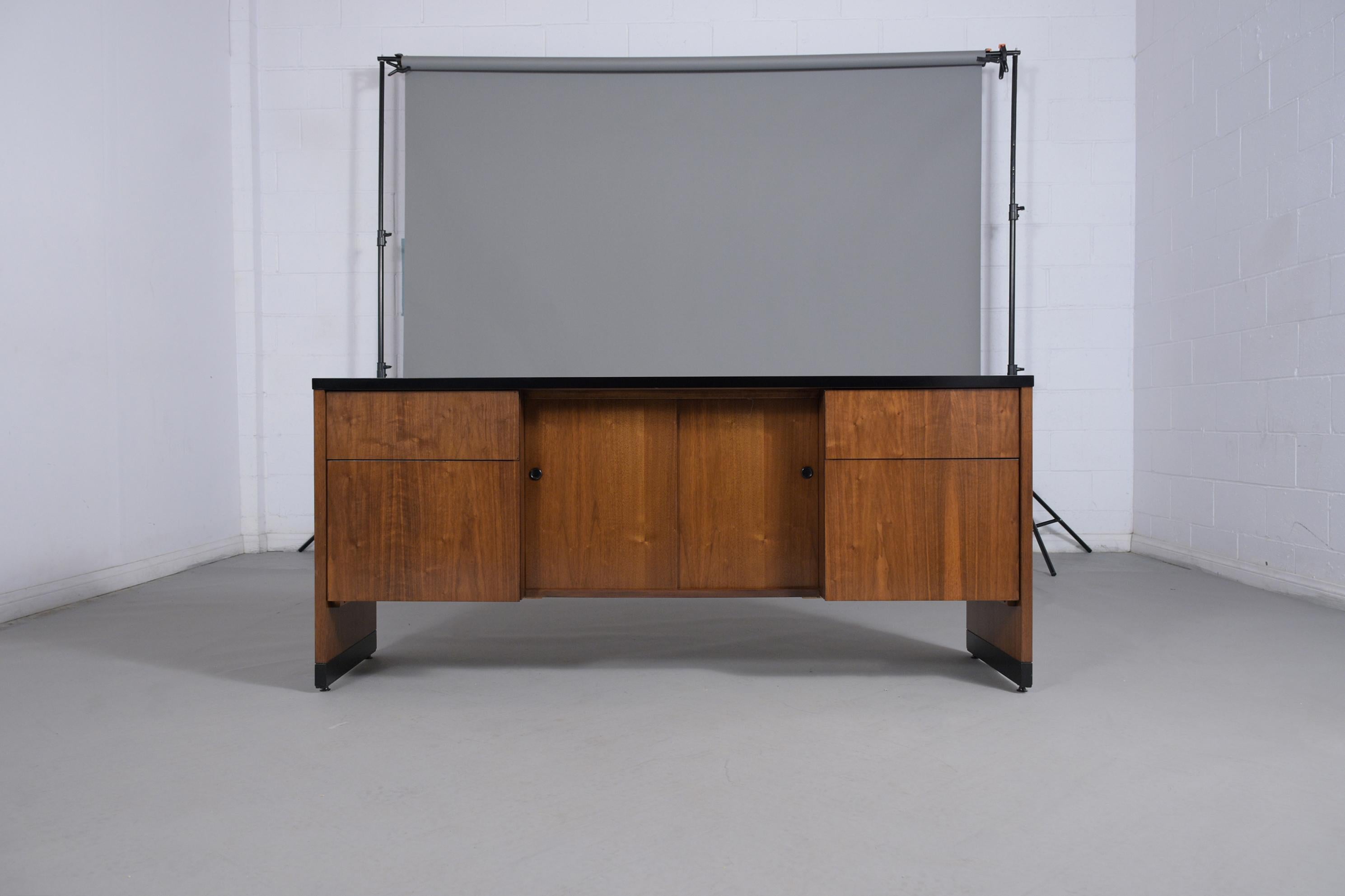 Embrace the timeless style of mid-century design with our fully restored Mid-Century Modern Executive Credenza. This exquisite piece, crafted from high-quality walnut wood, has undergone a meticulous restoration process by our expert craftsmen,