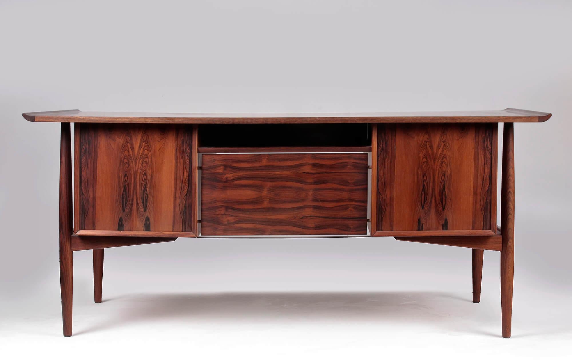 A large executive mahogany desk with matching armchair. Designed by Arne Vodder for H.P. Hansen's. Arne Vodder was one of the most important Danish architects or designer of the midcentury.