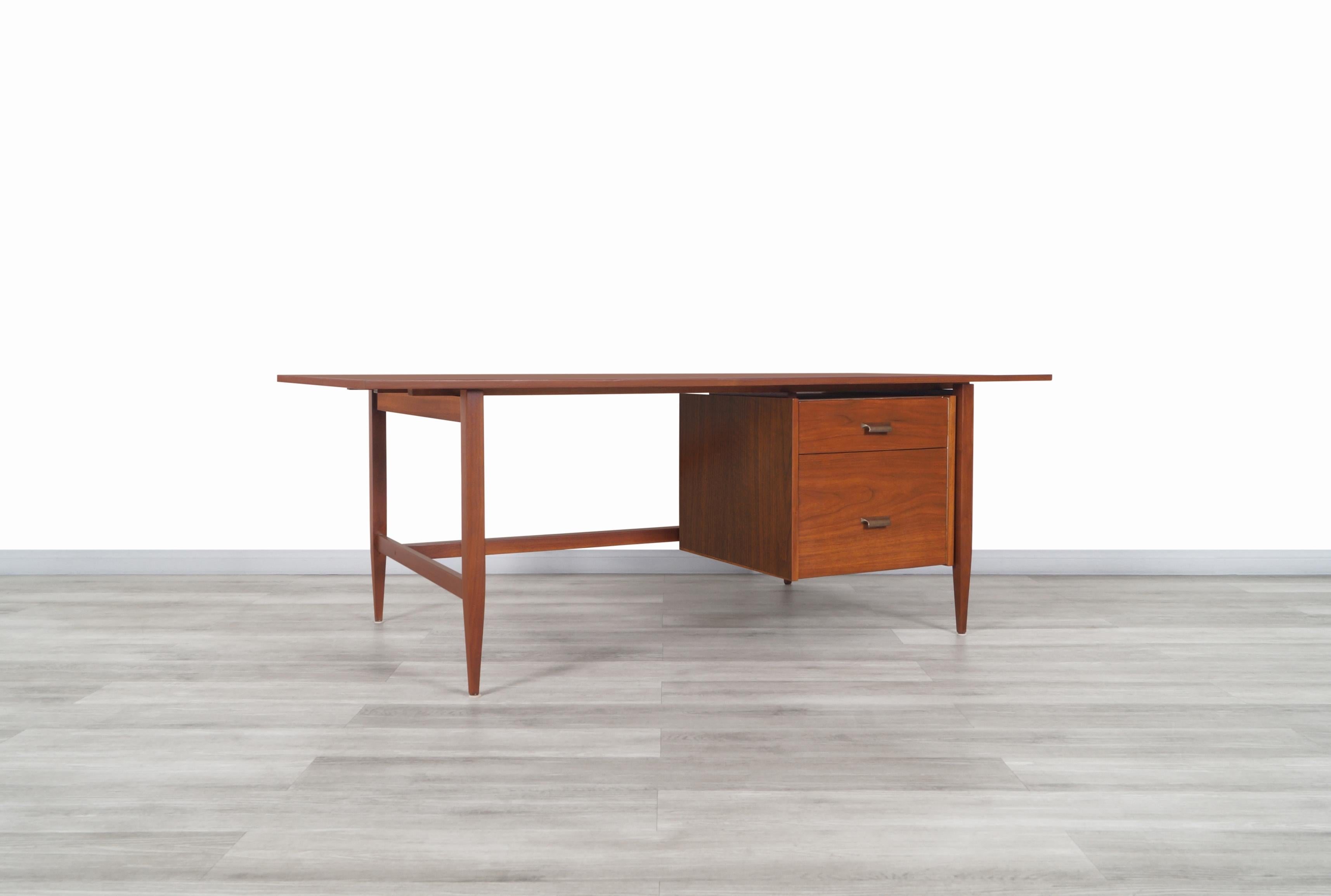 Fabulous mid-century executive walnut desk designed and manufactured in the United States, circa 1960s. This desk has been constructed from the highest quality walnut wood and features a practical design that perfectly fits any work environment.
