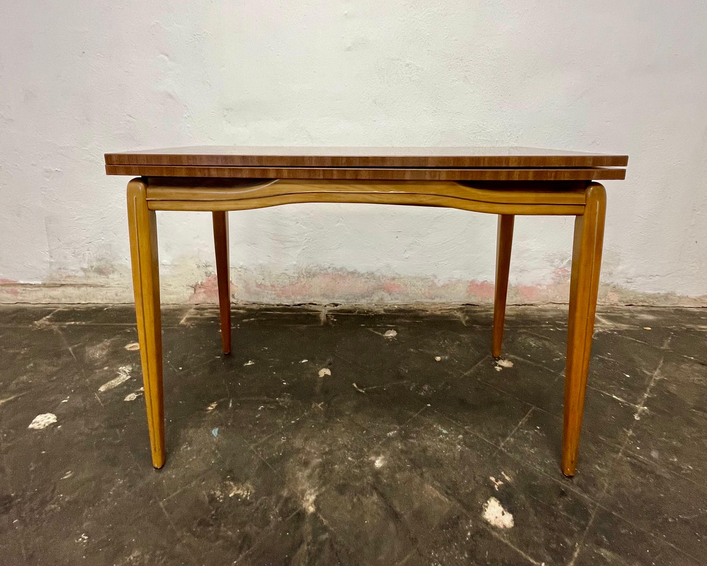 Fantastique table de salle à manger ou de jeu de style moderne du milieu du siècle dans le style de Gio Ponti. La base et les pieds en bois clair sont ornés d'un passepoil en laiton incrusté. Dessus en formica qui peut être doublé en le tirant et en