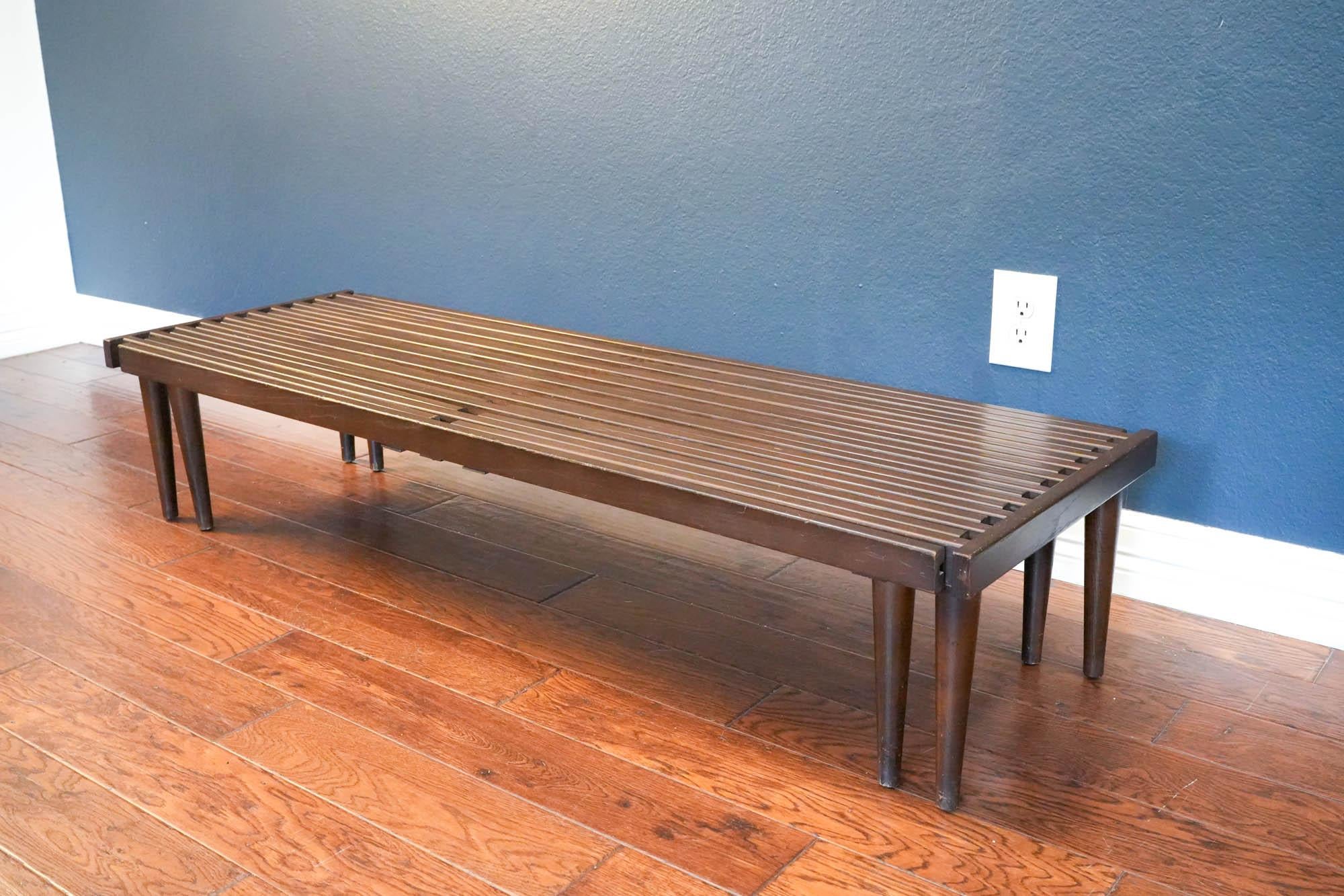 Exuding timeless appeal, this slatted wood bench by renowned mid-century modern designer John Keal embodies both functionality and clean-lined aesthetic. Crafted with meticulous attention to detail, the slatted top allows light to pass through,