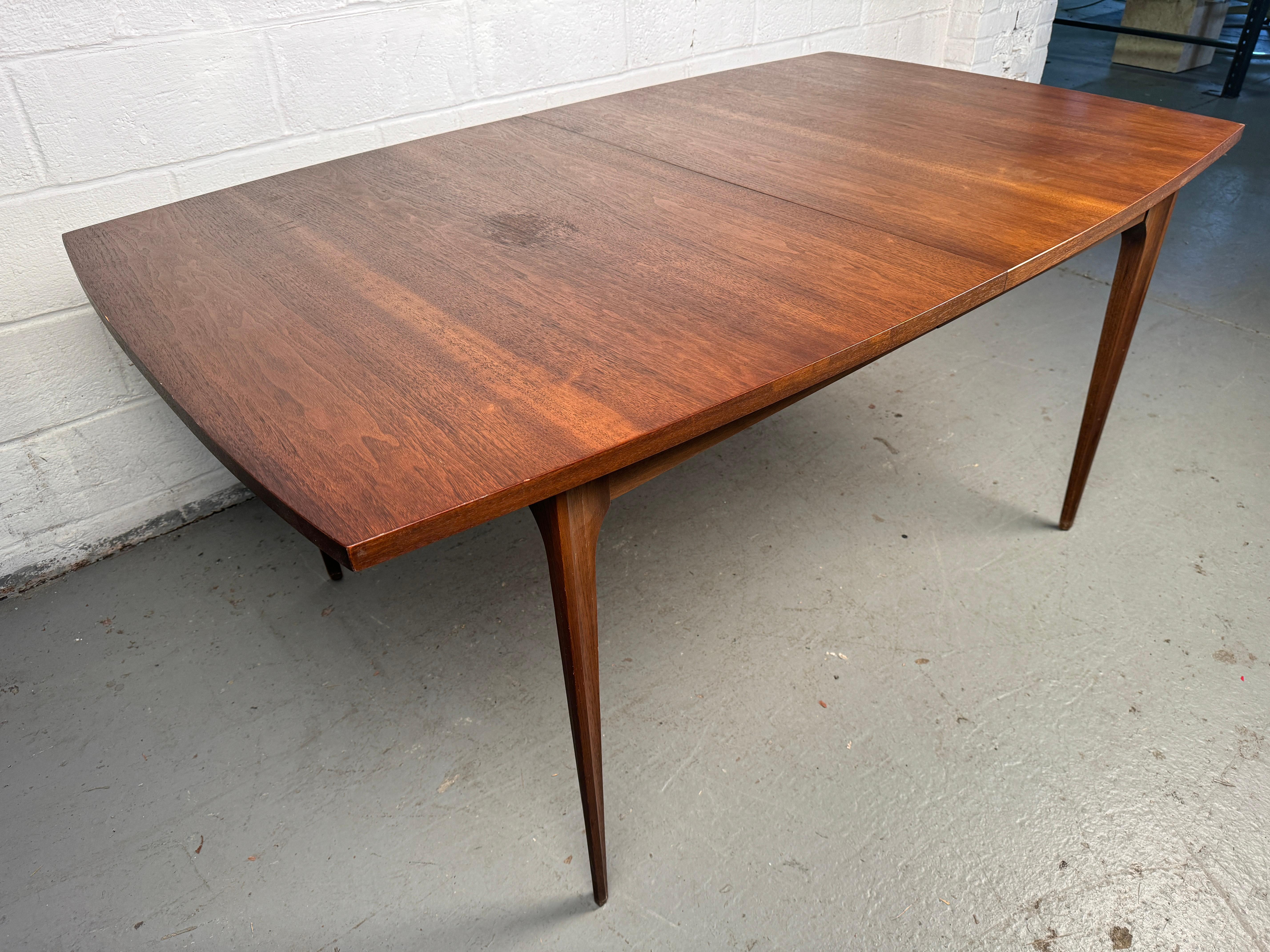 Inspirée par les formes architecturales audacieuses du Brasília d'Oscar Niemeyer, cette table de salle à manger en noyer en expansion de la Collection Brasilia emblématique de Broyhill est un véritable chef-d'œuvre du milieu du siècle. Artistics en
