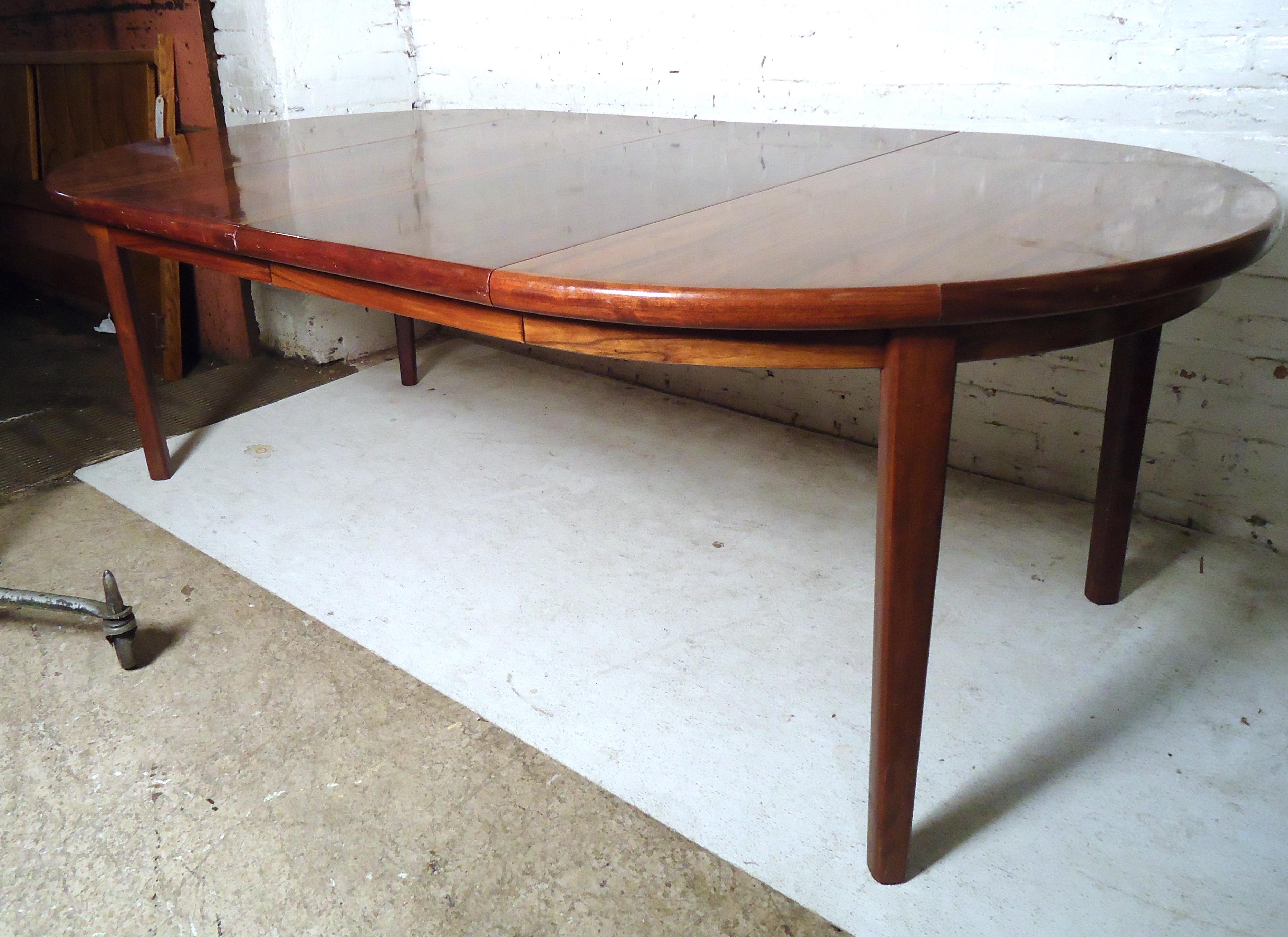 Gorgeous vintage modern Danish extendable dining table featured in rich rosewood grain by Rasmus. The table is extended from 46