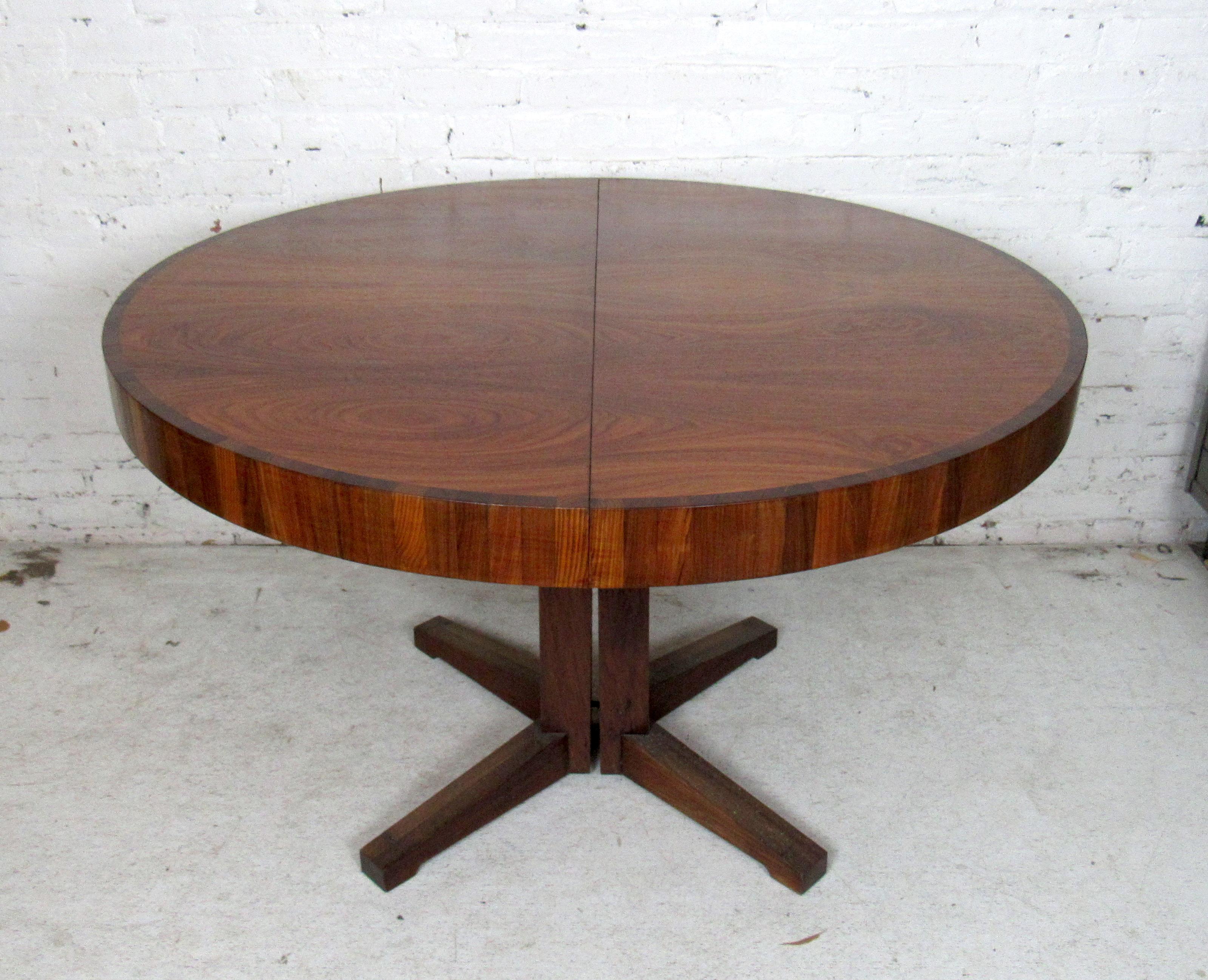 Vintage modern round dining table featured in rich rosewood grain. This dining table comes with a leaf that extends the length of the table into an oval shape.
Extends to 63