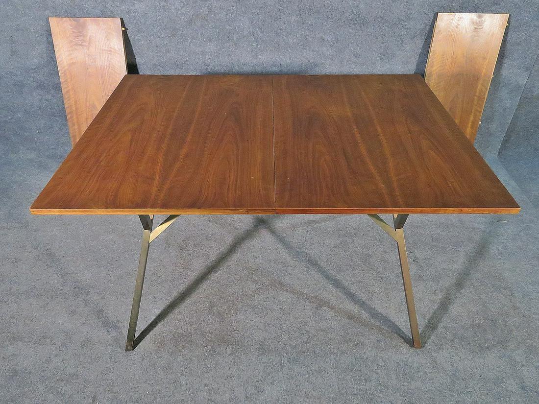 Vintage modern dining table featured in rich walnut grain, on a splayed metal base.

Please confirm item location (NY or NJ).

With leaves: 82