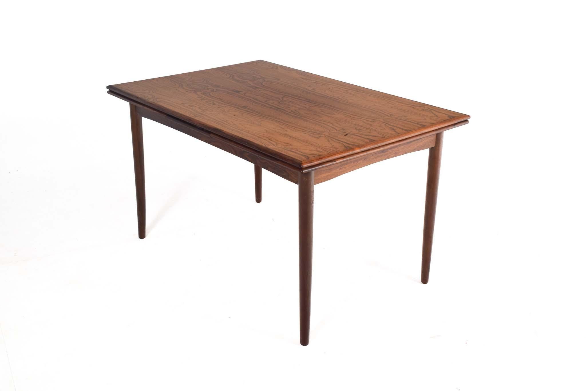 Magnifique table de salle à manger à rallonge du milieu du siècle en bois de rose, fabriquée par un ébéniste danois dans les années 1960. Cette table peut également offrir un espace généreux et presque doubler de taille une fois ses feuilles de