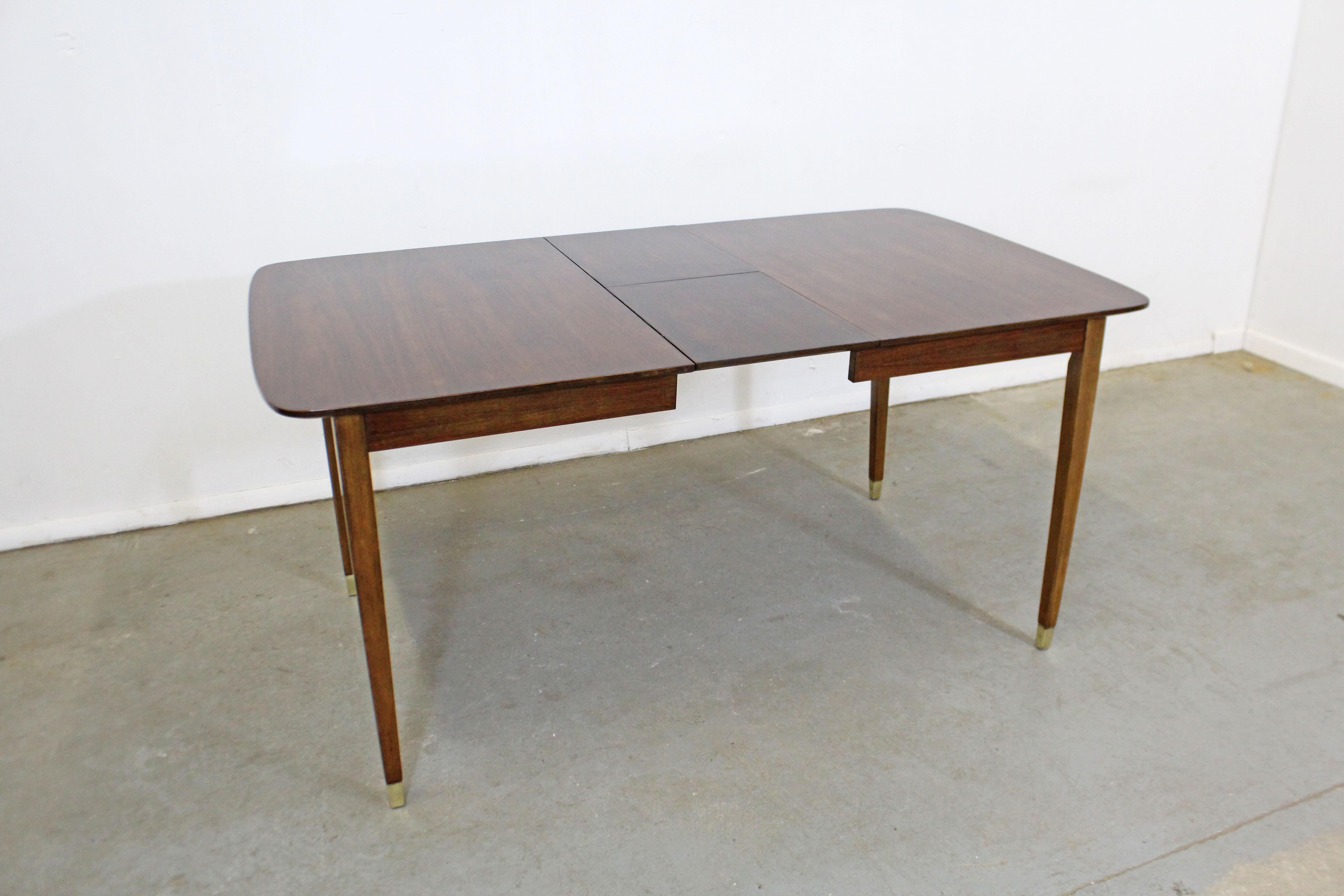 Offered is a vintage Mid-Century Modern dining table with a hidden 12