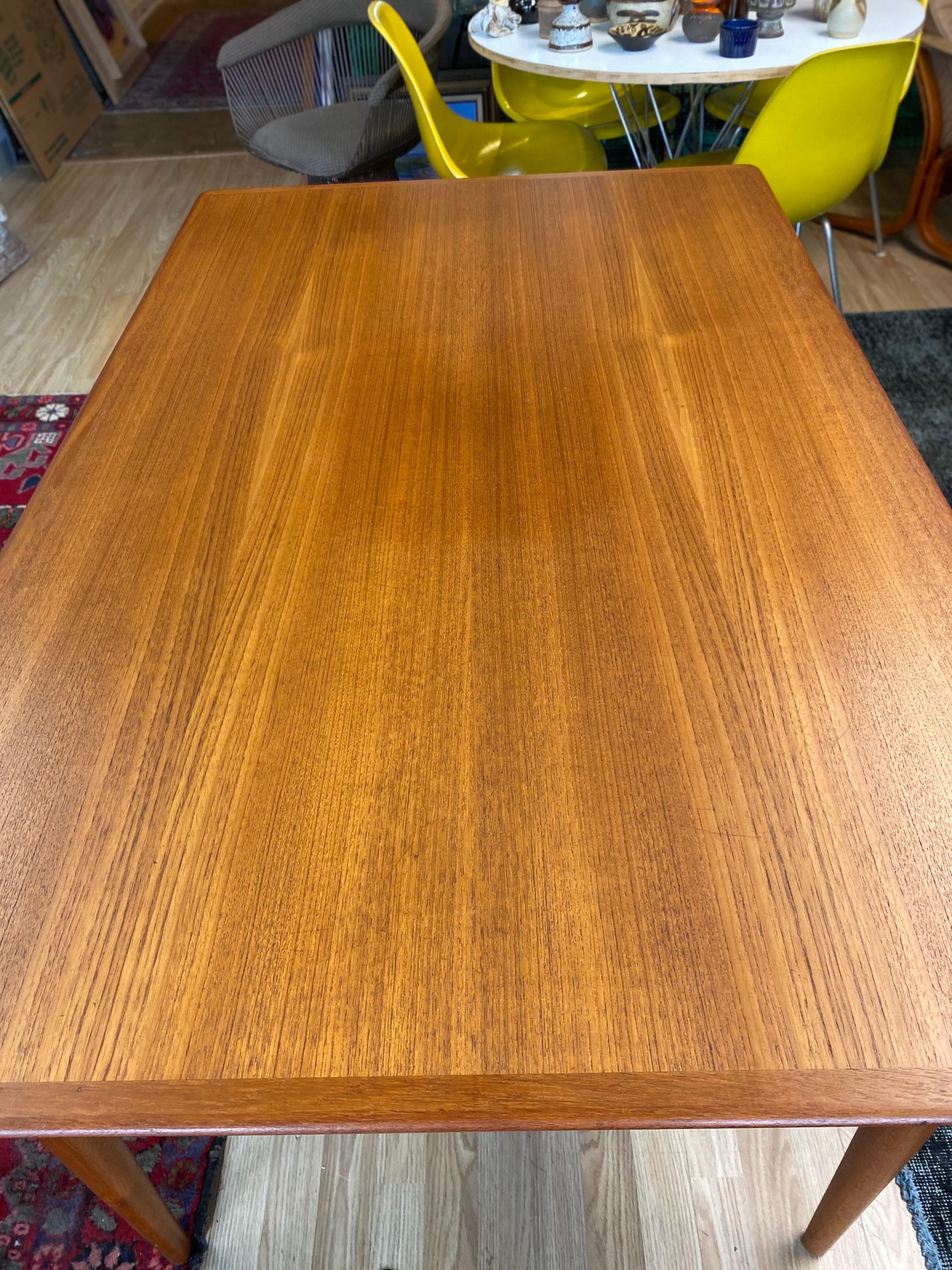 Beautiful teak dining table by Moreddi features two hidden extendable leaves and is stamped with Moreddi on bottom of the dining table. This table easily sits 6 and when extended sits up to 8. This vintage Danish dining table is in great overall