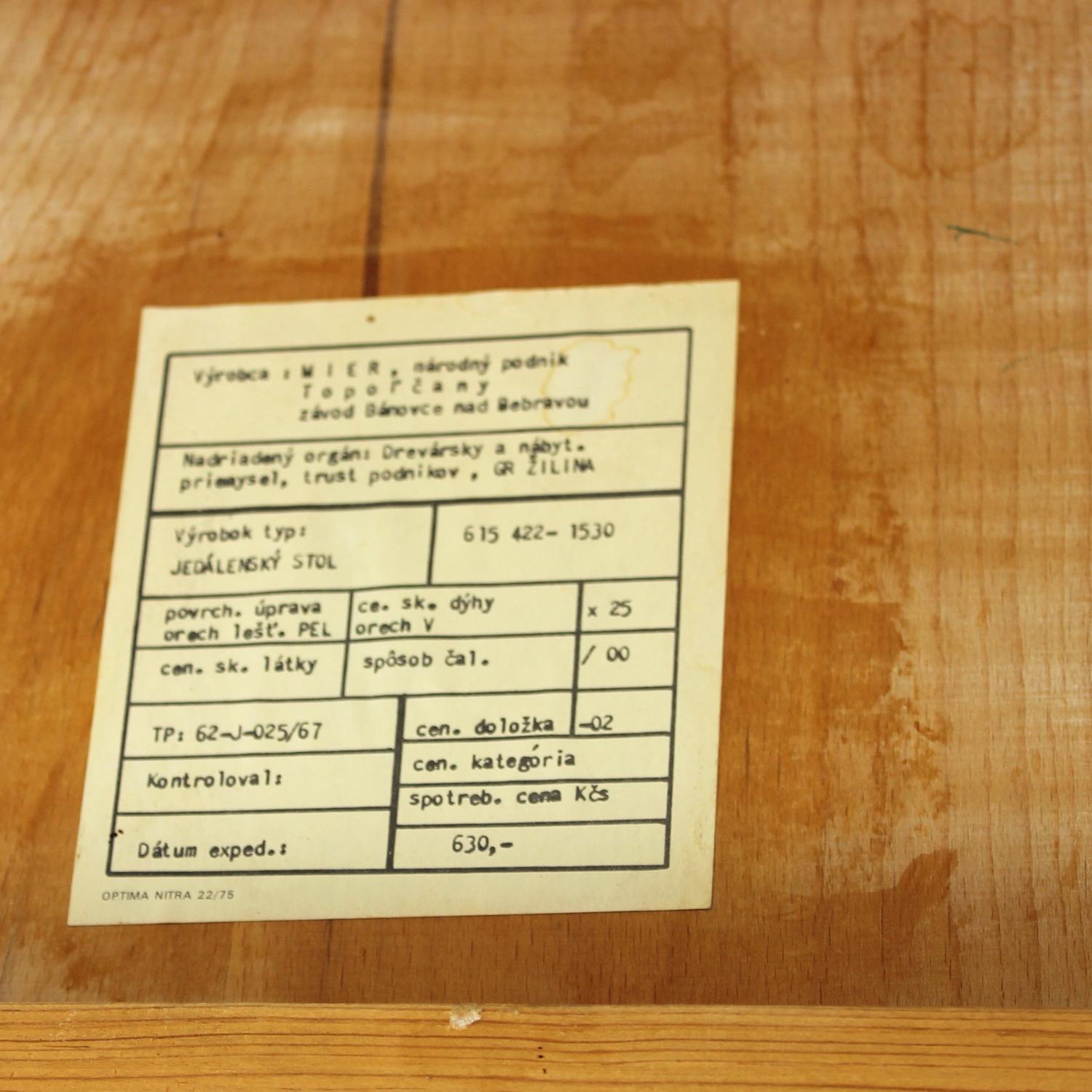 Beautiful mid-century dining table produced by Mier in Czechoslovakia during the 1960s, with the original label still attached. The table stands on four rounded screw-on legs for easy transport and storage. The top features a rich walnut veneer with