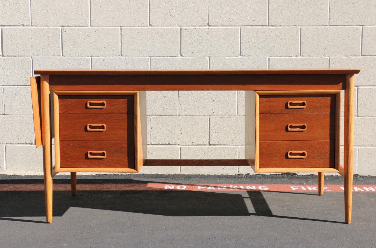 Spectacular Danish modern floating writing desk manufactured by Arne Vodder, and original from the 1960’s. There is plenty of storage with one lateral file drawer, a five more  drawers. Also, it has an extension that extends the top to 74.5in when