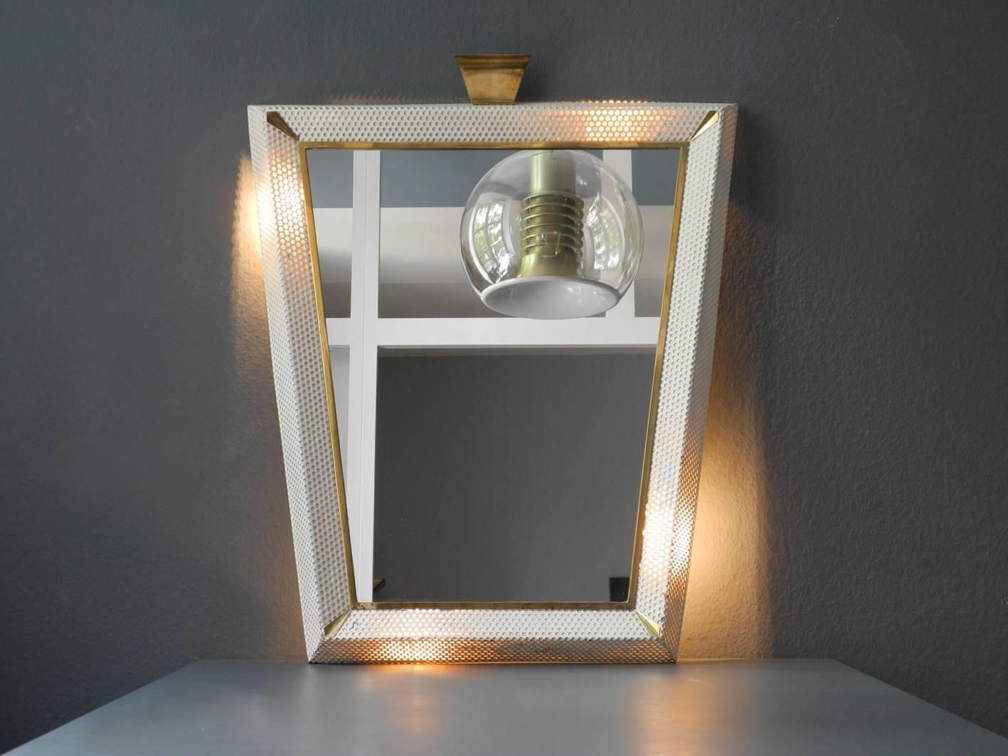 Original Mid-Century Modern extra large illuminated mirror with perforated metal frame and brass details. Made in France.
Beautiful design in a conical shape. With many nice details made of brass.
On the back there is an E27 socket on each corner.
