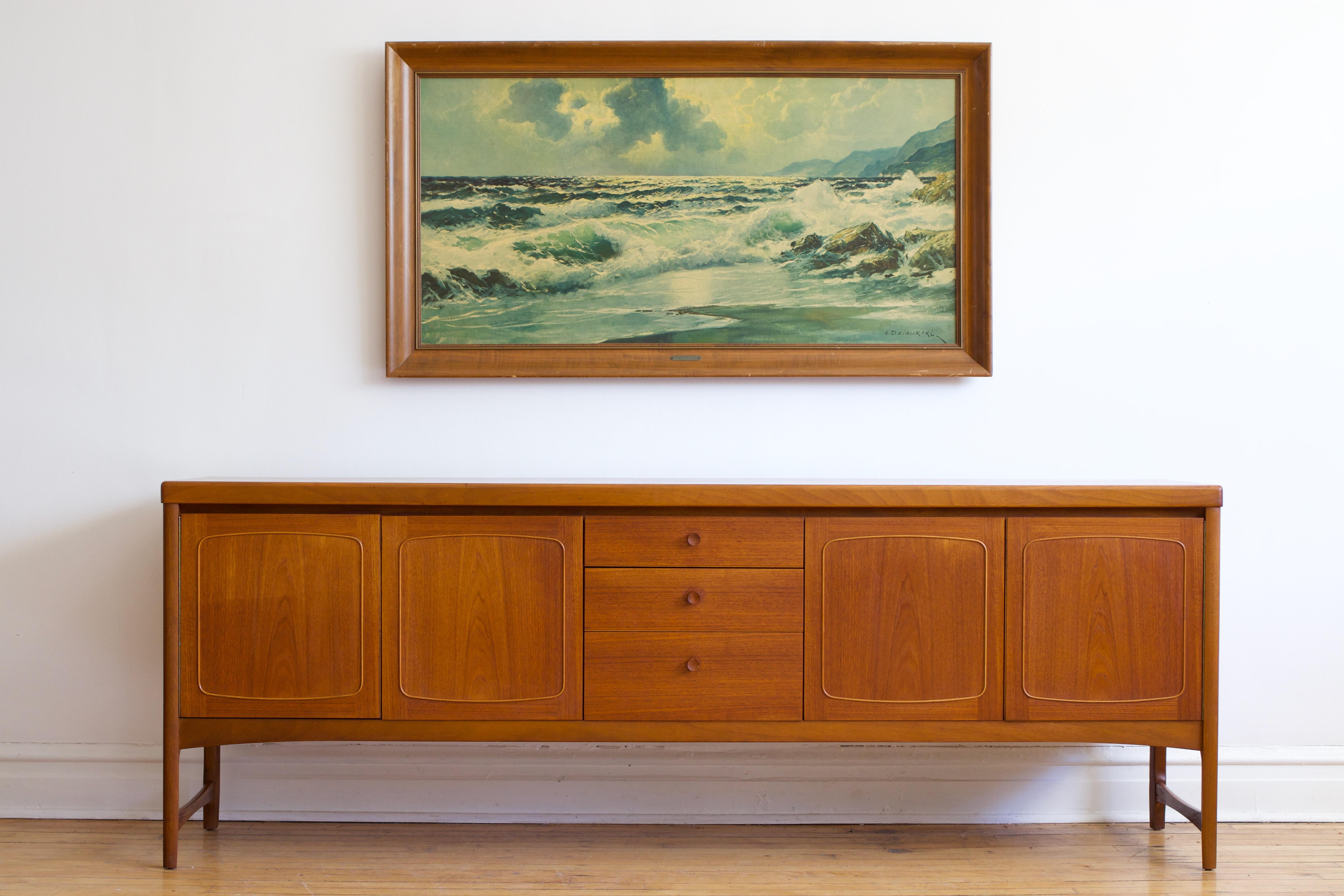Mid-century Danish Modern extra large teak wood sideboard.
Made in London by Nathan Furniture.
Just imported from England to Chicago.
This one is slightly taller and longer than the average sideboard.
Three dovetailed drawers; top drawer holds