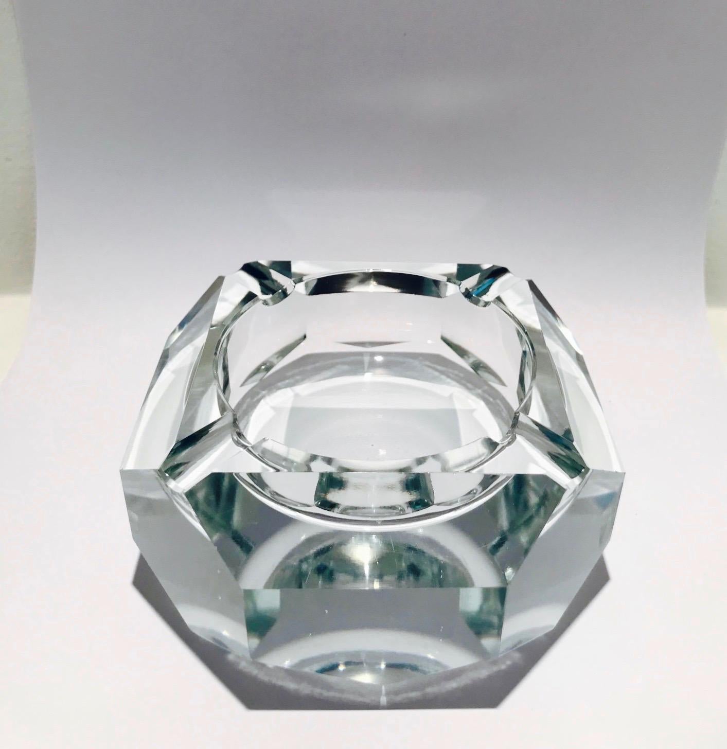 Stunning cut crystal ashtray with faceted design creating prisms of light. The ashtray has eight sides, but is predominantly square in form. Shines like a diamond and is heavy in weight. Fitted with four notches for cigarettes, or can be used as