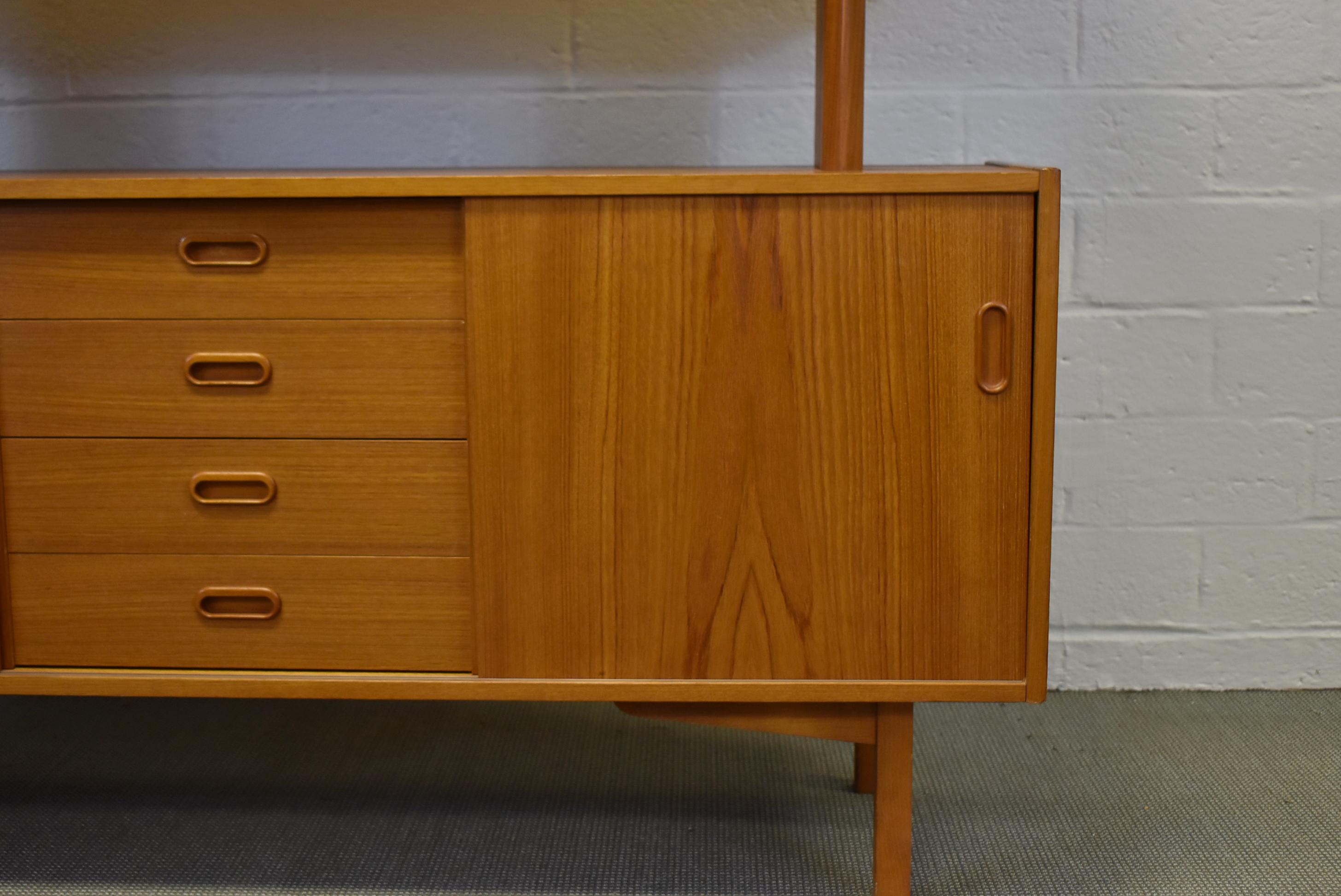 Mid-Century Modern Danish teak credenza with display top by Falster. Two doors conceal adjustable shelves. Removeable display cabinet top. It has two sliding glass doors with two adjustable shelves. Very nice to excellent condition. 55