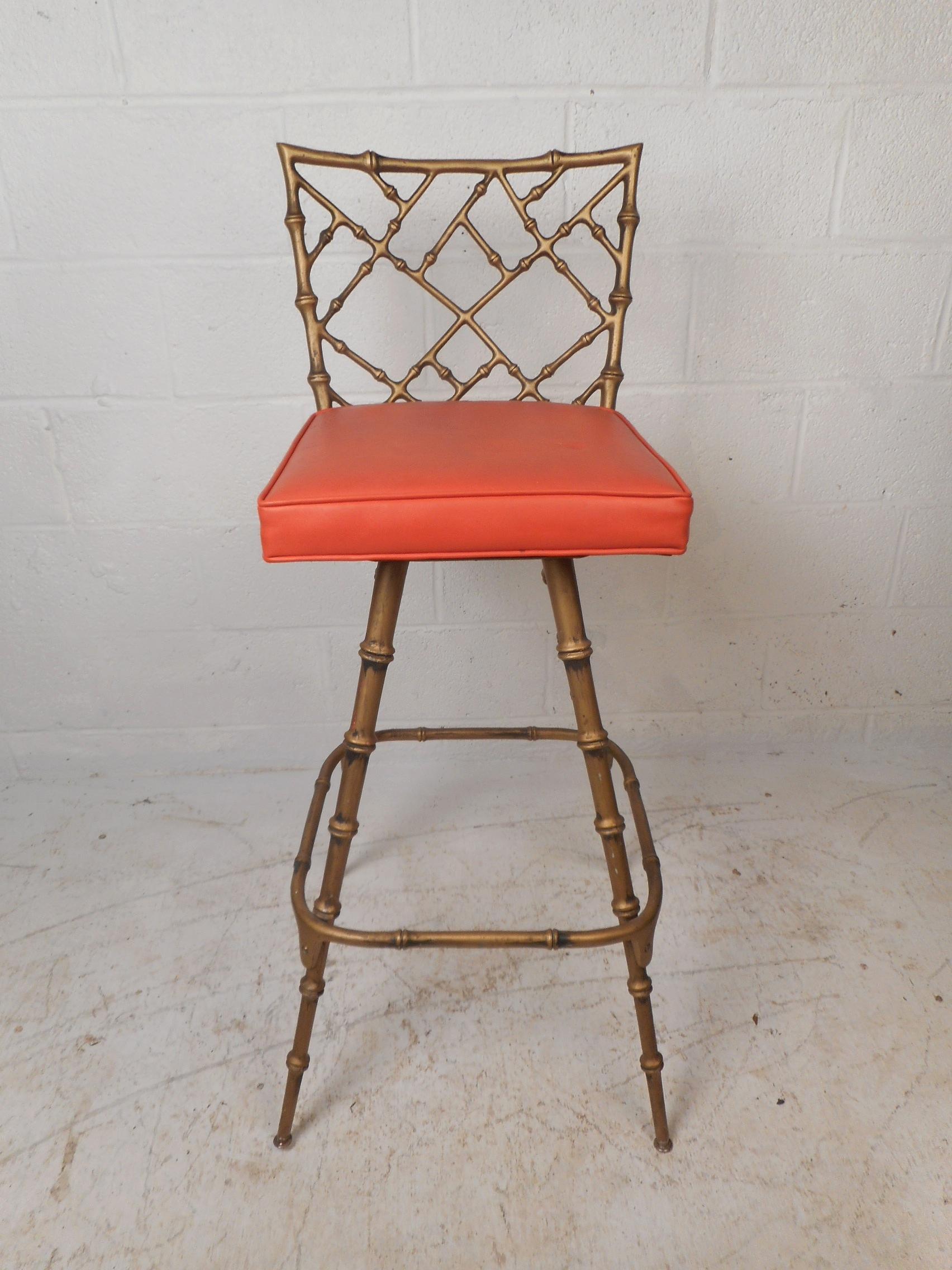 These vintage modern barstools by Kessler Industries have a Hollywood Regency style and are great for any setting. They feature candy red vinyl seats sitting in a frame of faux bamboo with splayed legs. The seats of these sleek stools swivel and the