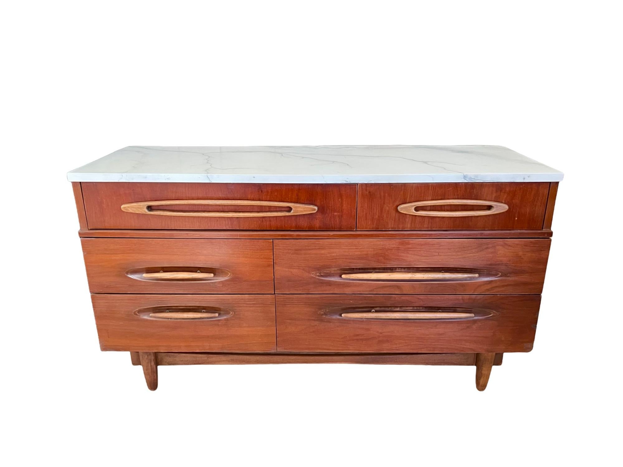 A vintage mid-century modern six drawer dresser by Ward Furniture. Featuring a hand painted faux marble wood top in white with cream, gold, gray and blue undertones and veins in shades of gray, gold, blue and charcoal. Below, sculpted capsule-shape