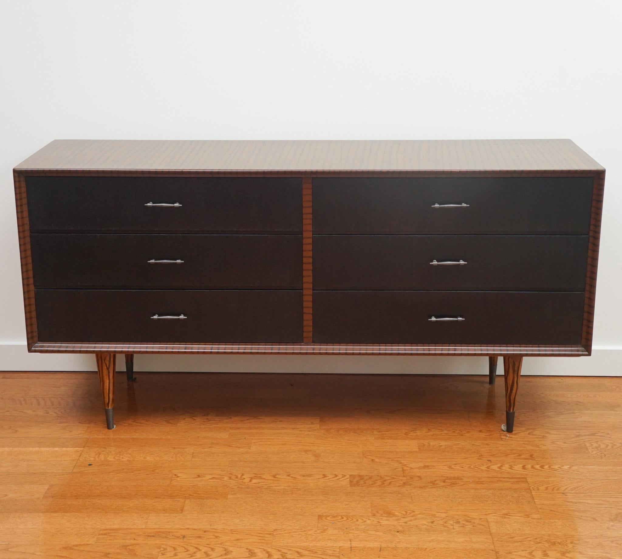 The faux zebra wood mid-century dresser, shown here, has been beautifully restored.  Featuring six generous-sized drawers, the exotic zebra-patterned finish is made even more dramatic with black painted drawer fronts and modern silver pulls.   Circa